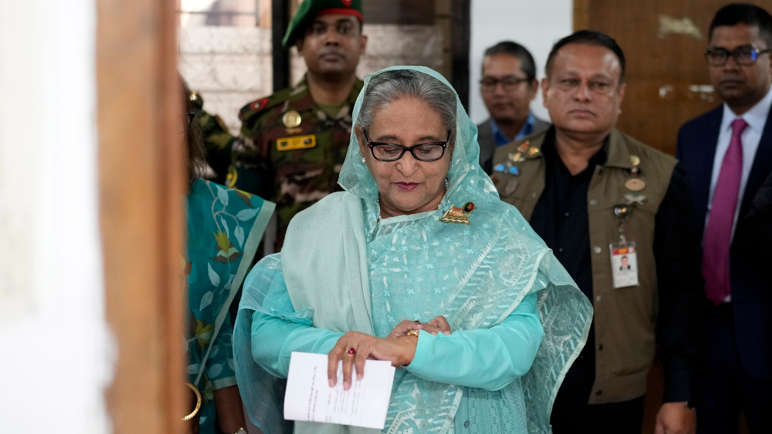 Bangladesh Prime Minister Sheikh Hasina checks her watch as she waits for the official opening time to cast her vote in Dhaka, Bangladesh, Jan. 7, 2024. (AP Photo/Altaf Qadri)