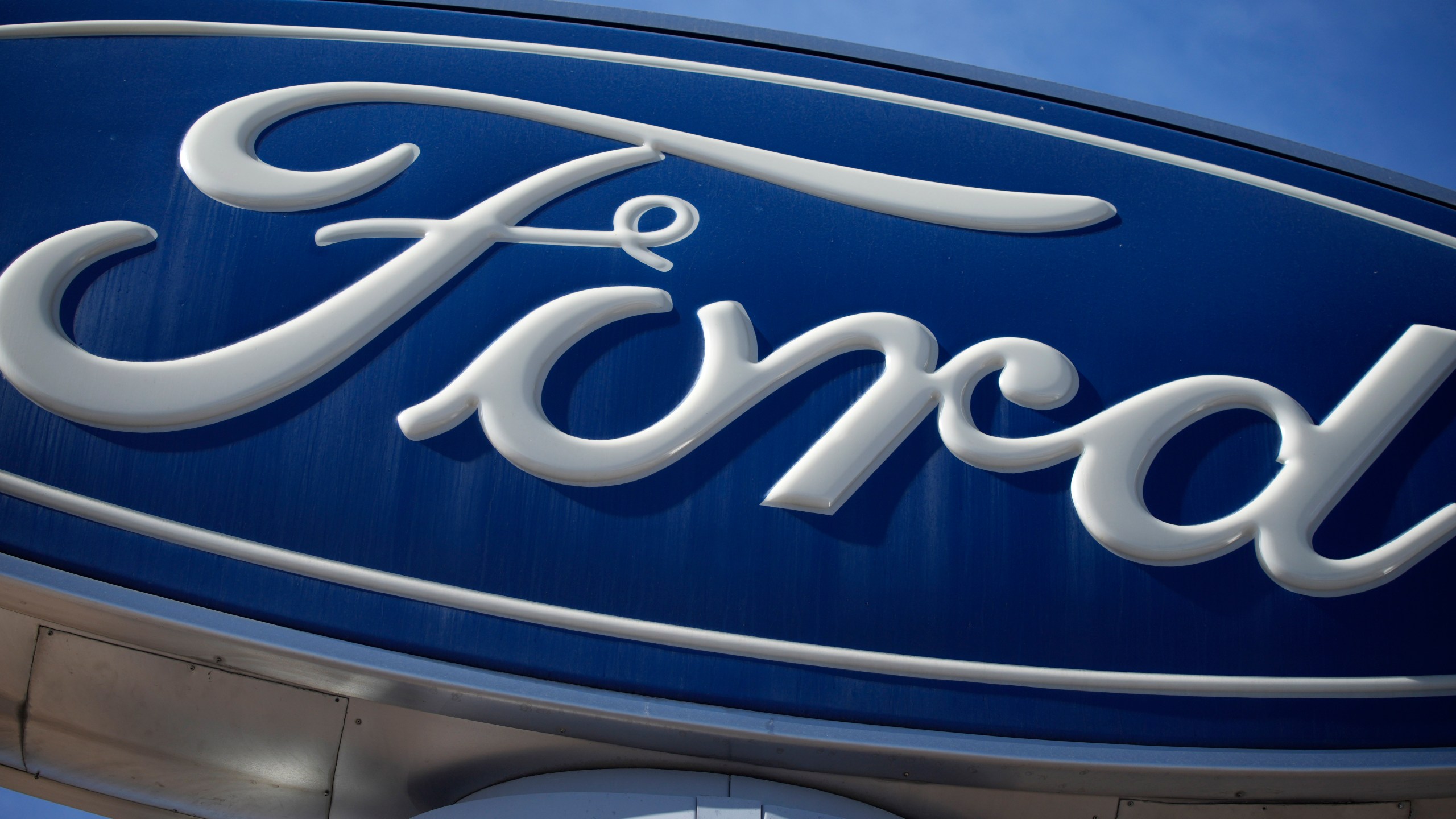 FILE - The Ford company logo is seen, Oct. 24, 2021, on a sign at a Ford dealership in southeast Denver. (AP Photo/David Zalubowski, File)