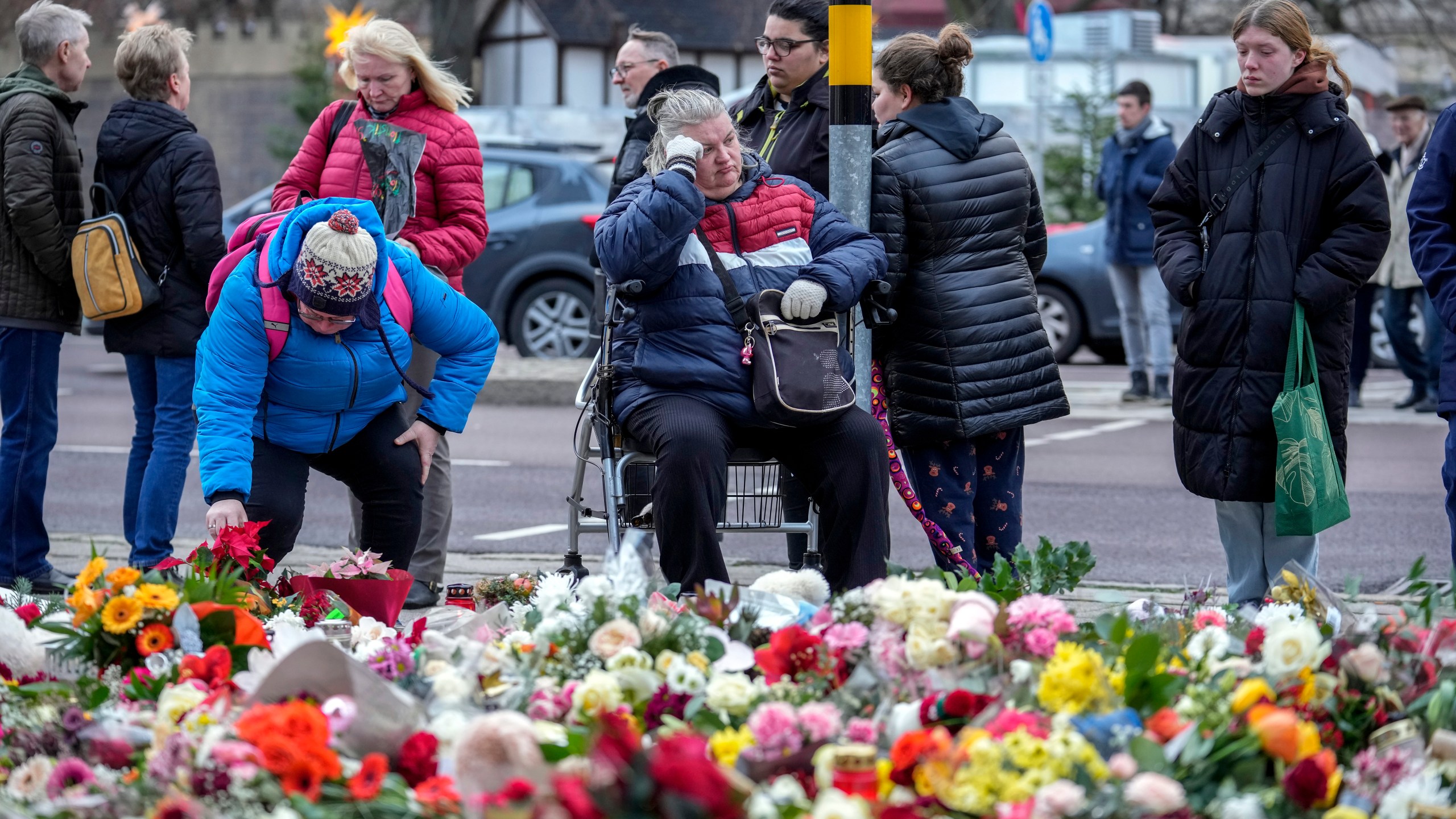 People lay flowers and candles in front of the Johannis church close to the Christmas market where a car drove into a crowd on Friday evening, in Magdeburg, Germany, Monday, Dec. 23, 2024. (AP Photo/Ebrahim Noroozi)