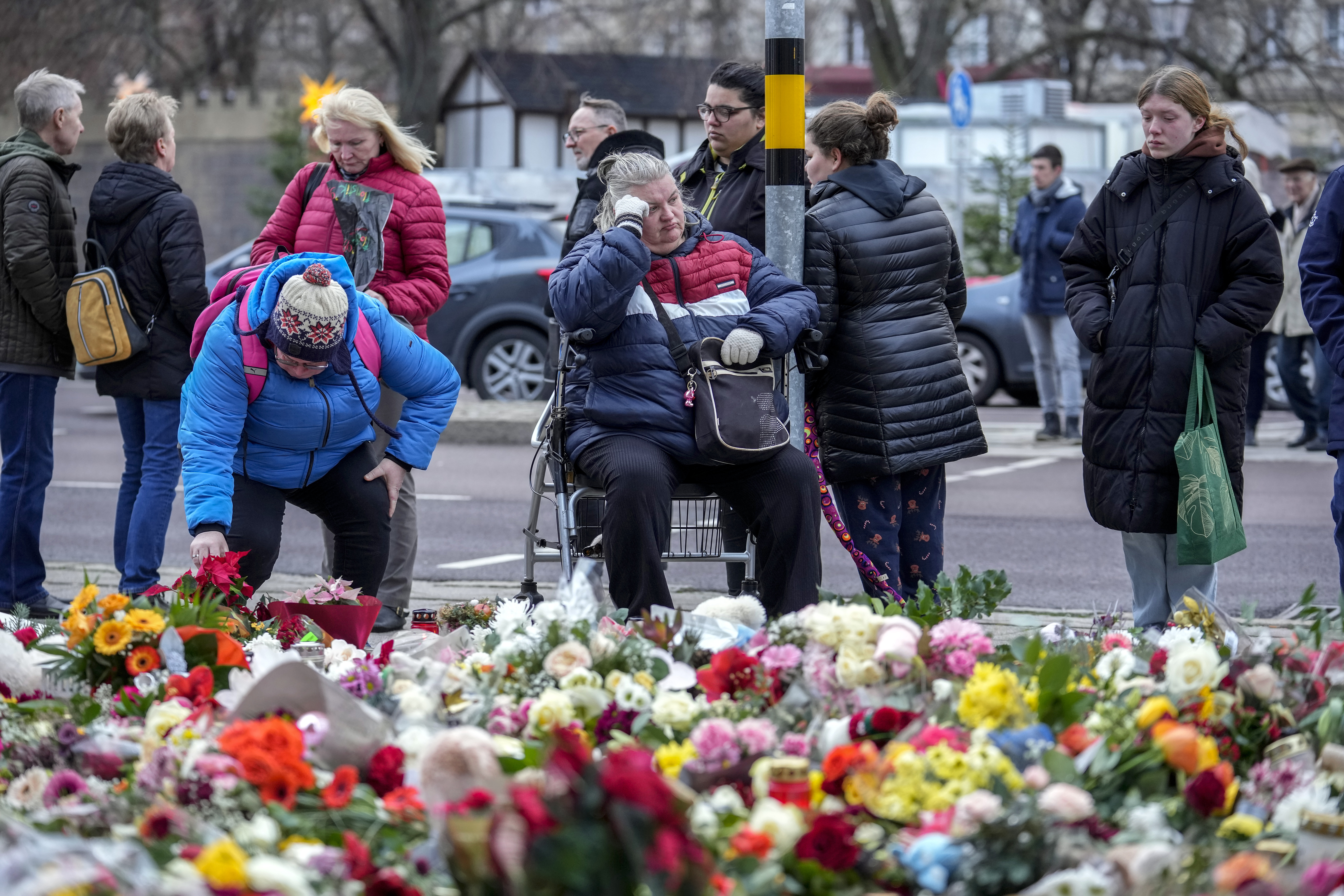 People lay flowers and candles in front of the Johannis church close to the Christmas market where a car drove into a crowd on Friday evening, in Magdeburg, Germany, Monday, Dec. 23, 2024. (AP Photo/Ebrahim Noroozi)