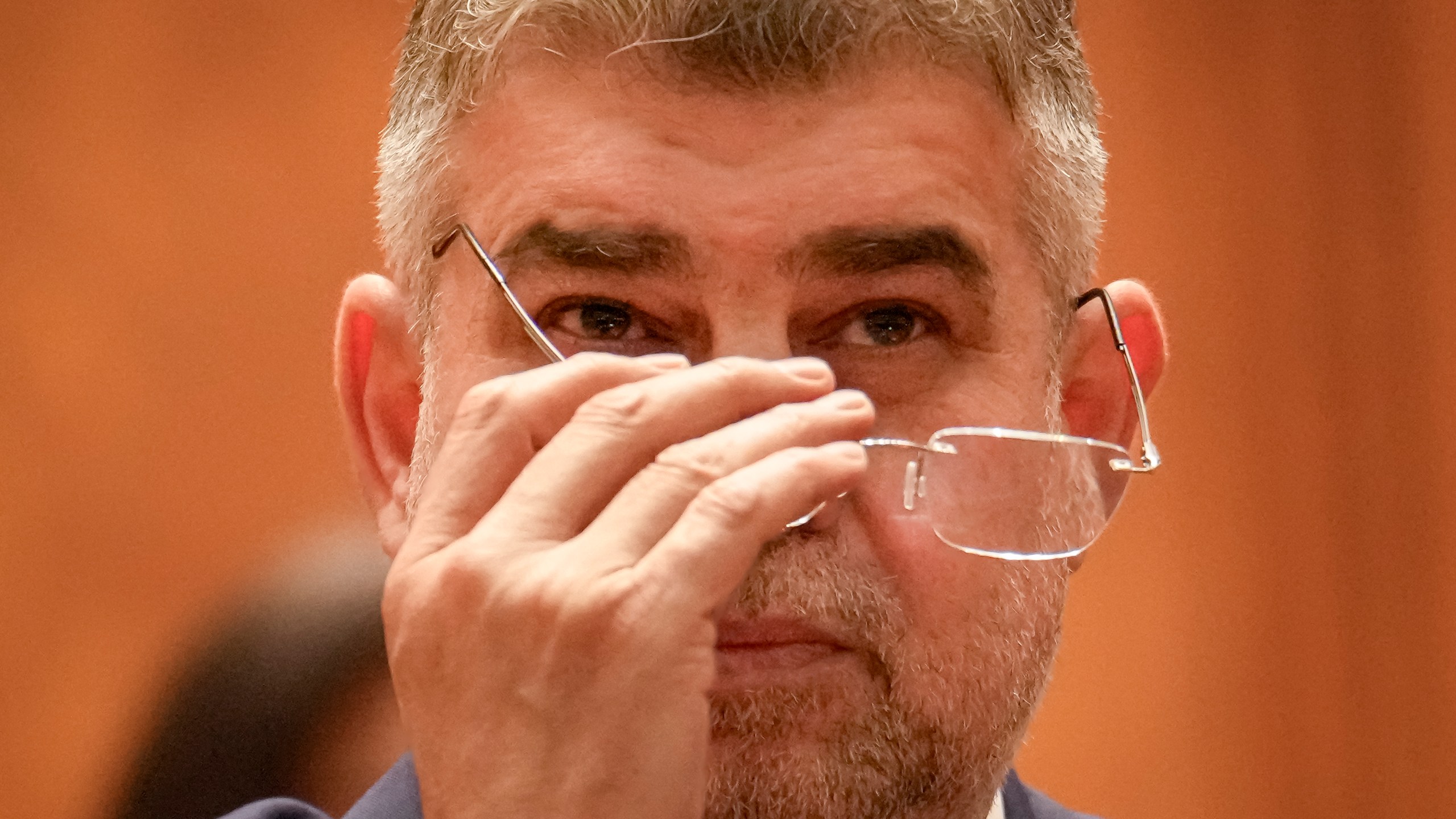 Romanian Prime Minister designate Marcel Ciolacu, the leader of the Social Democratic party, adjusts his glasses before a confidence vote for him and his team at the parliament in Bucharest, Romania, Monday, Dec. 23, 2024. (AP Photo/Vadim Ghirda)