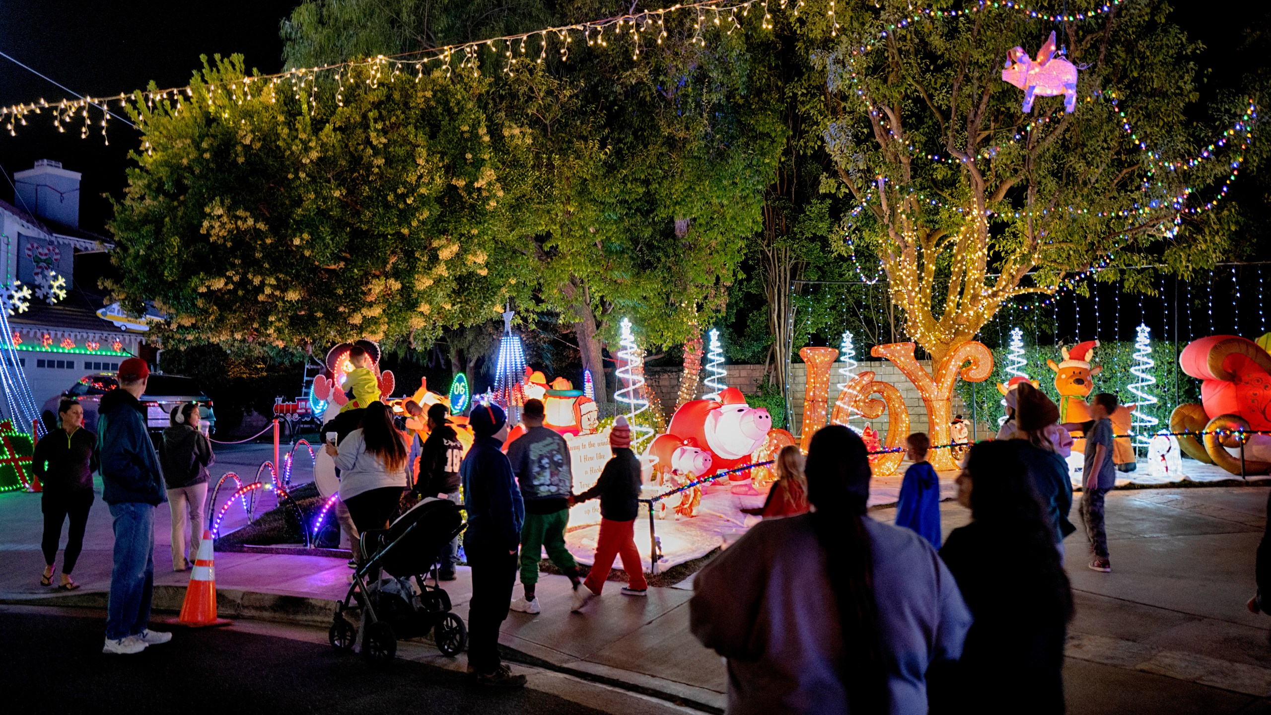 Local residents walk through the Wakefield Winter Wonderland neighborhood decorated with Christmas lights in Santa Clarita, Calif. on Dec. 17, 2024. (AP Photo/Richard Vogel)