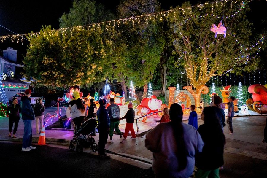 Local residents walk through the Wakefield Winter Wonderland neighborhood decorated with Christmas lights in Santa Clarita, Calif. on Dec. 17, 2024. (AP Photo/Richard Vogel)