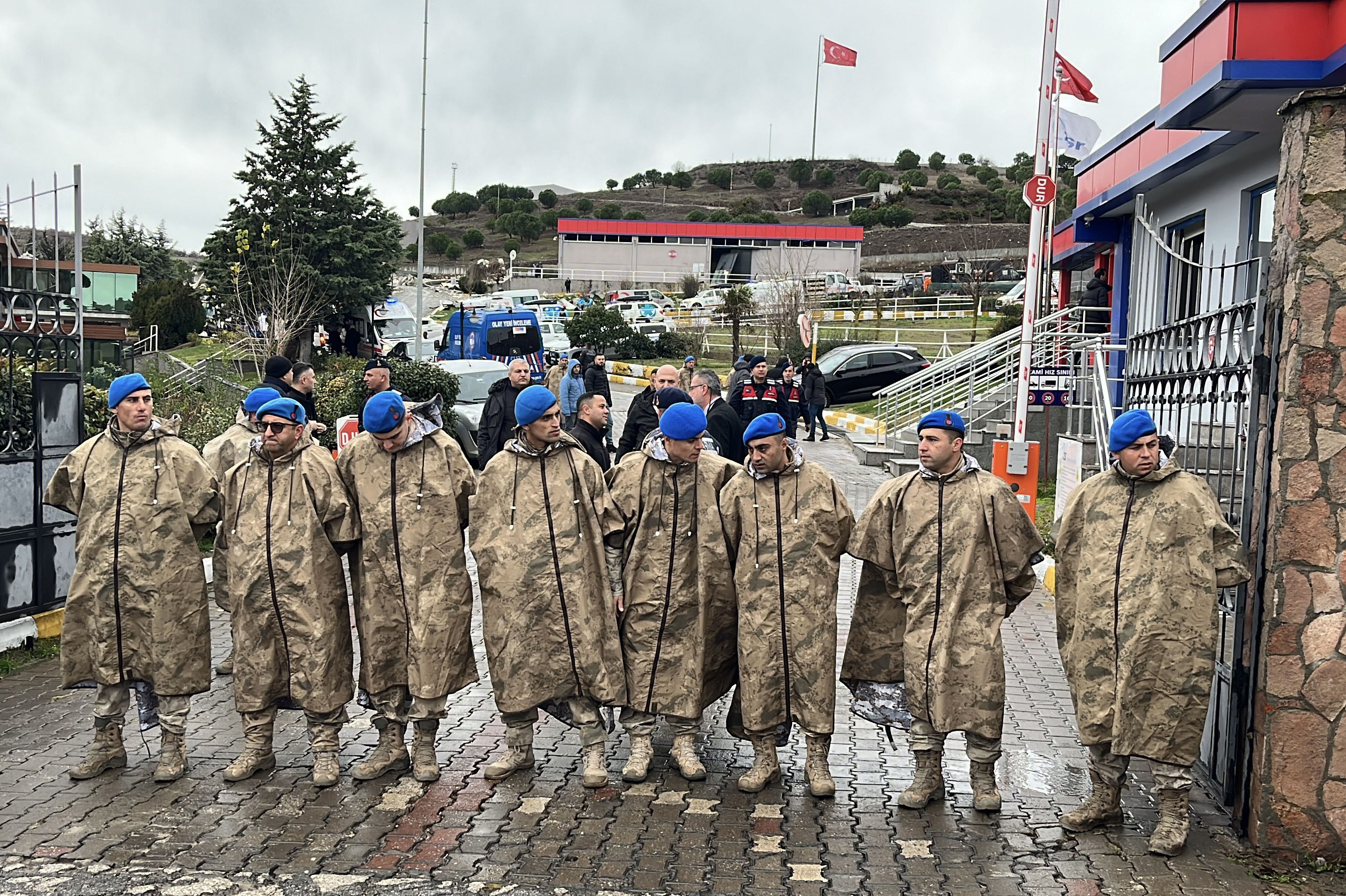 Turkish security forces stand guard next to parked ambulances at the entrance of an armament factory following an explosion that killed several people, in Balikesir, northwest Turkey, Tuesday, Dec. 24, 2024. (IHA via AP)