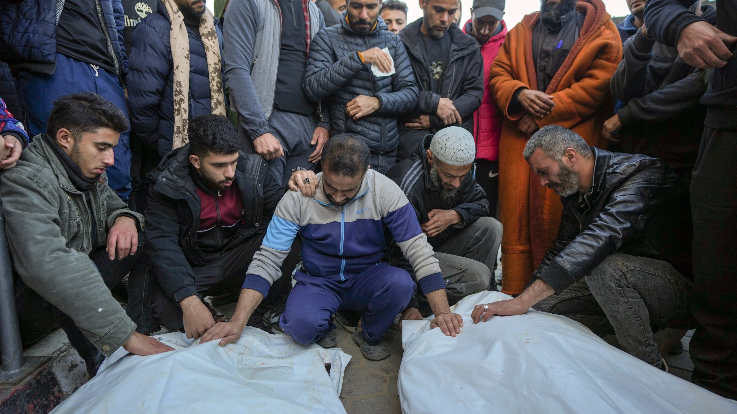 Palestinians mourn over the bodies of five policemen killed Monday by an Israeli strike in Deir al-Balah, central Gaza Strip, Tuesday Dec. 24, 2024. According to witnesses at the scene, the policemen fired shots to prevent a group of bandits blocking the road from stealing aid from a truck. The Israeli army immediately struck the policemen after that.(AP Photo/Abdel Kareem Hana)