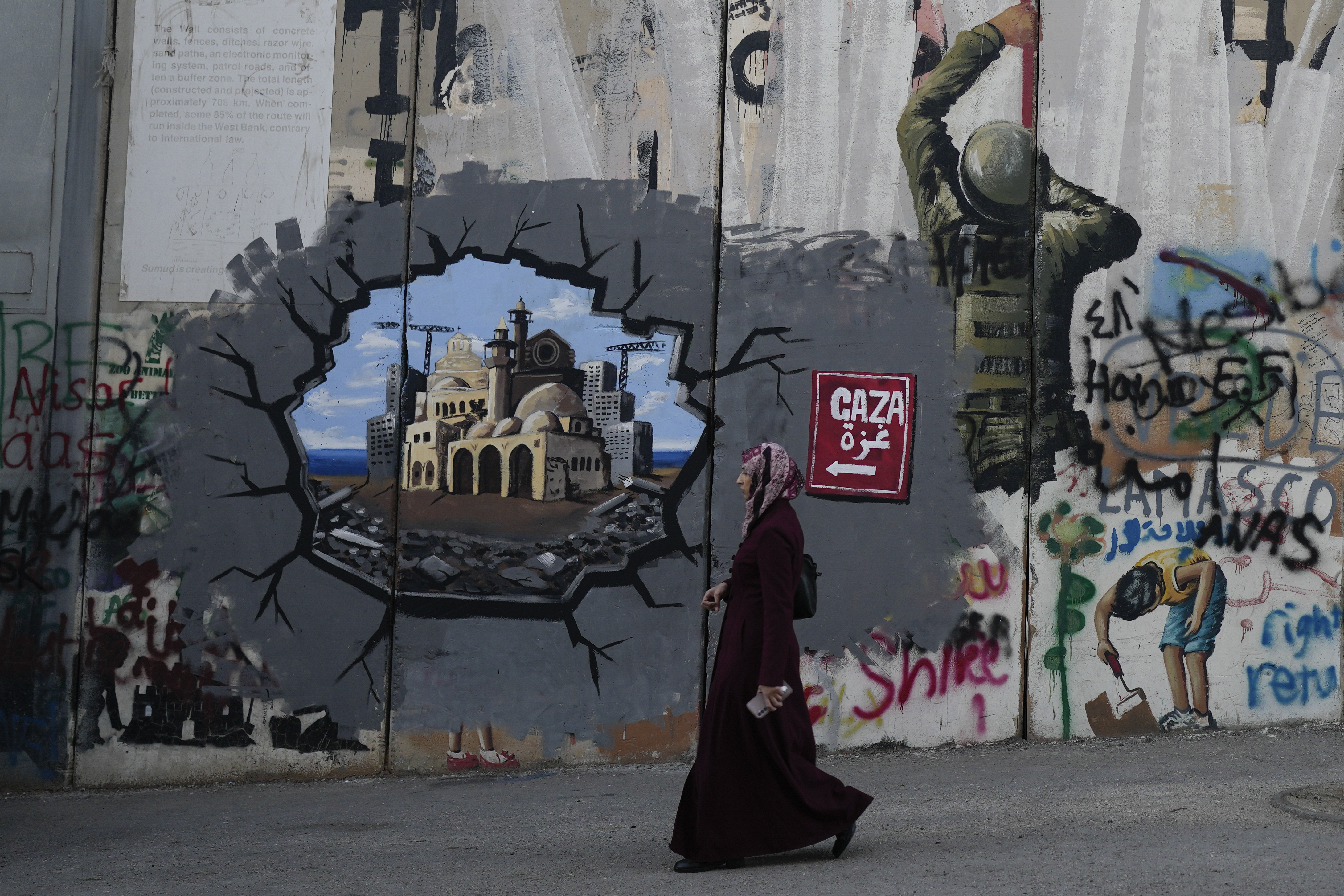 Murals cover Israel's separation barrier in the West Bank city of Bethlehem on Christmas Eve, Tuesday, Dec. 24, 2024. (AP Photo/Matias Delacroix)