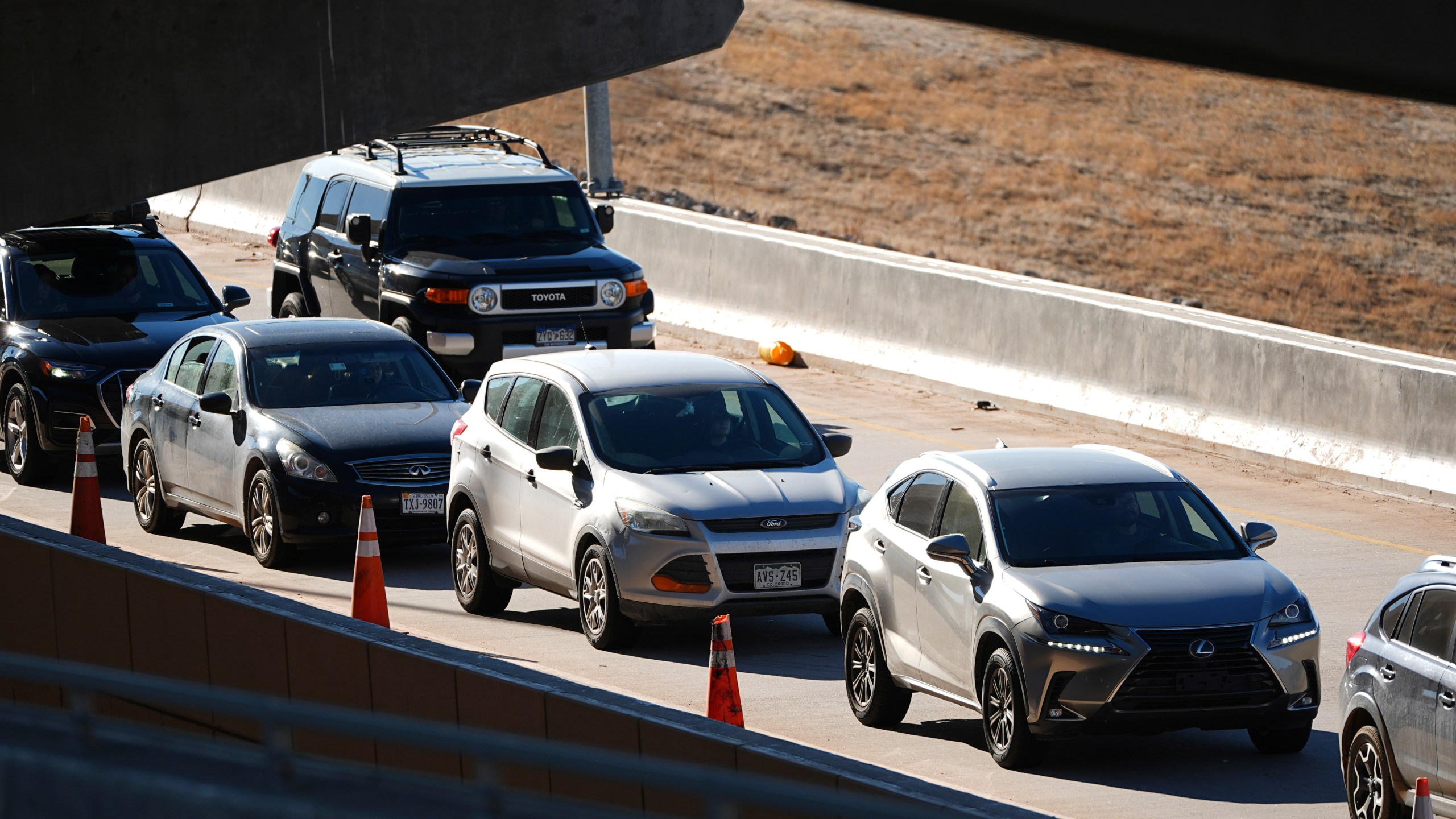 Motorists sit in a long line to pick up travelers arriving in the main terminal of Denver International Airport Tuesday, Dec. 24, 2024, in Denver. (AP Photo/David Zalubowski)