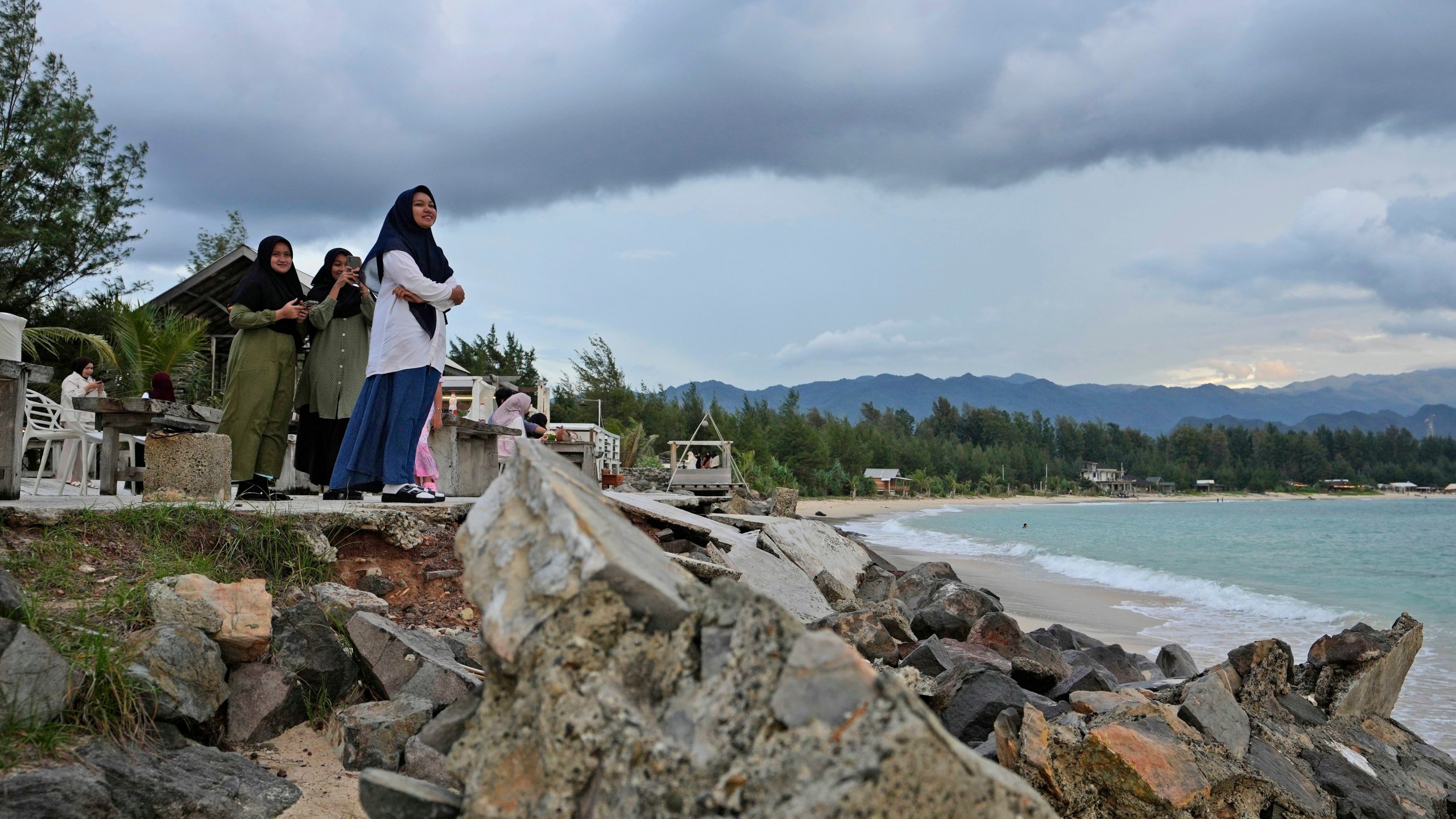 Young girls enjoy the view at Lampuuk beach, one of the areas hardest hit by Indian Ocean tsunami in 2004, on the outskirts of Banda Aceh, Indonesia, Friday, Dec. 13, 2024. (AP Photo/Achmad Ibrahim)