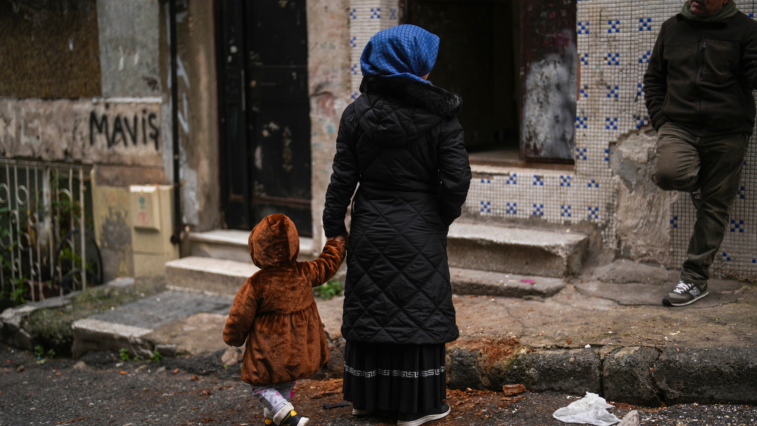 Mehmet Yeralan, 53, a volunteer, talks to a local woman with her child in the Tarlabasi neighborhood in Istanbul, Turkey, Wednesday, Dec. 4, 2024. (AP Photo/Francisco Seco)