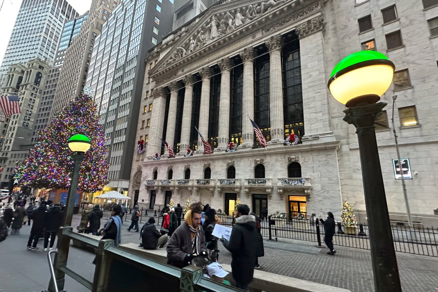 Lights marking the entrance to a subway station frame the New York Stock Exchange in New York's Financial District on Monday, Dec. 23, 2024. (AP Photo/Peter Morgan)