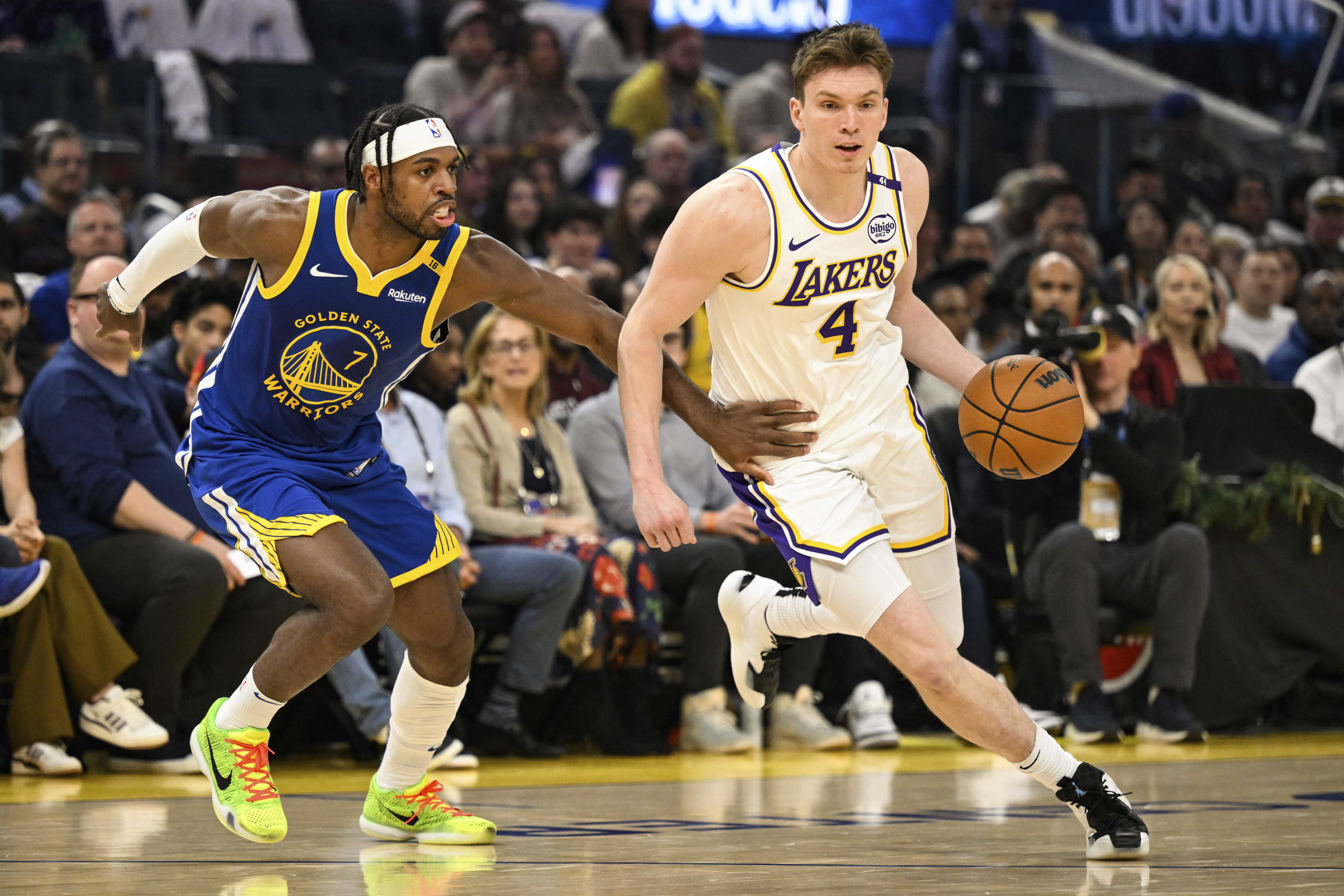 Los Angeles Lakers guard Dalton Knecht (4) dribbles against Golden State Warriors guard Buddy Hield (7) during the first half of an NBA basketball game, Wednesday, Dec. 25, 2024, in San Francisco. (AP Photo/Eakin Howard)