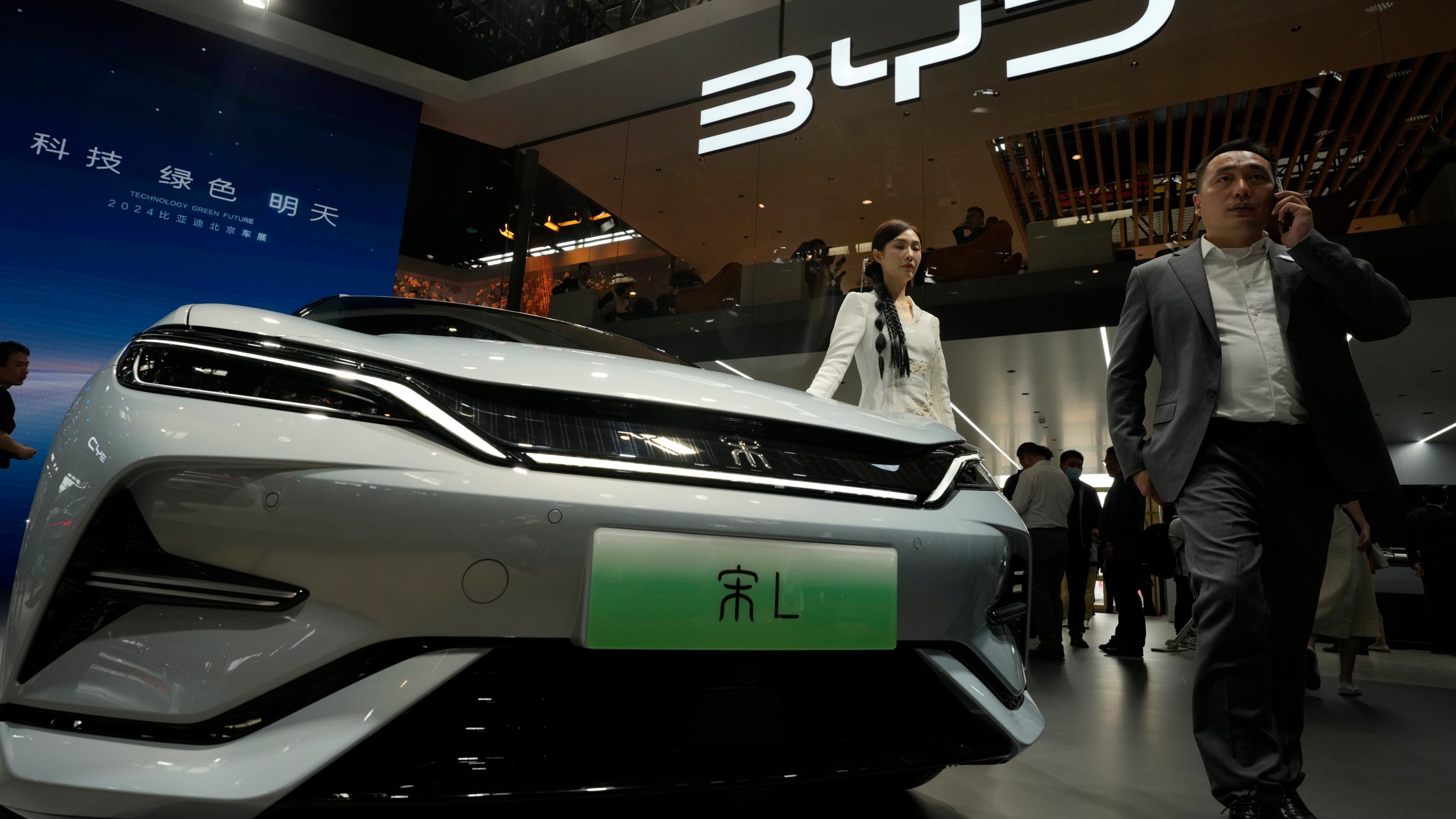 FILE - A model poses near the BYD Song L EV car during Auto China 2024 held in Beijing, April 25, 2024. (AP Photo/Ng Han Guan, File)