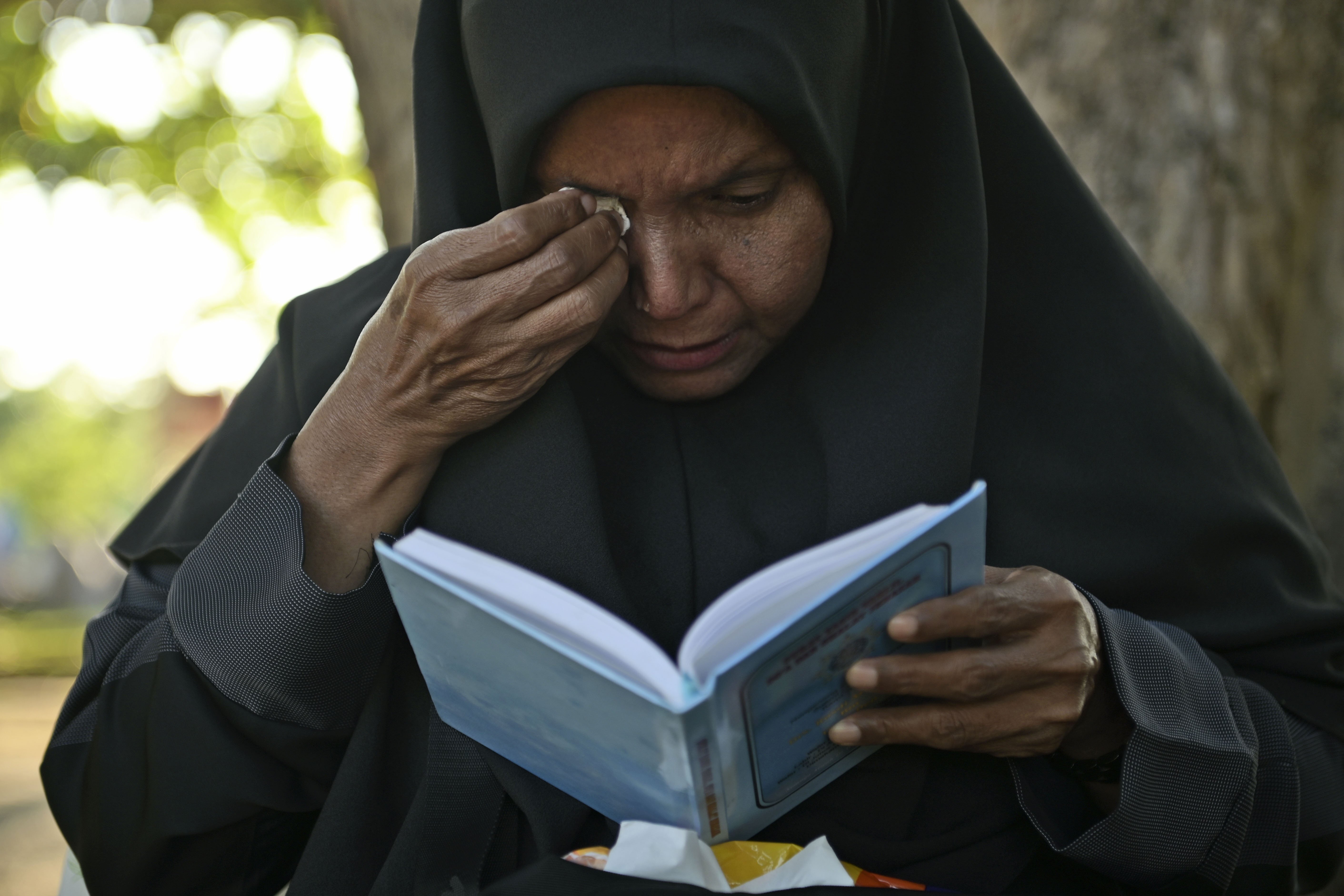 A woman weeps as she prays at a mass grave at victims of the 2004 Indian Ocean tsunami, in Banda Aceh, Indonesia, Thursday, Dec. 26, 2024. (AP Photo/Reza Saifullah)