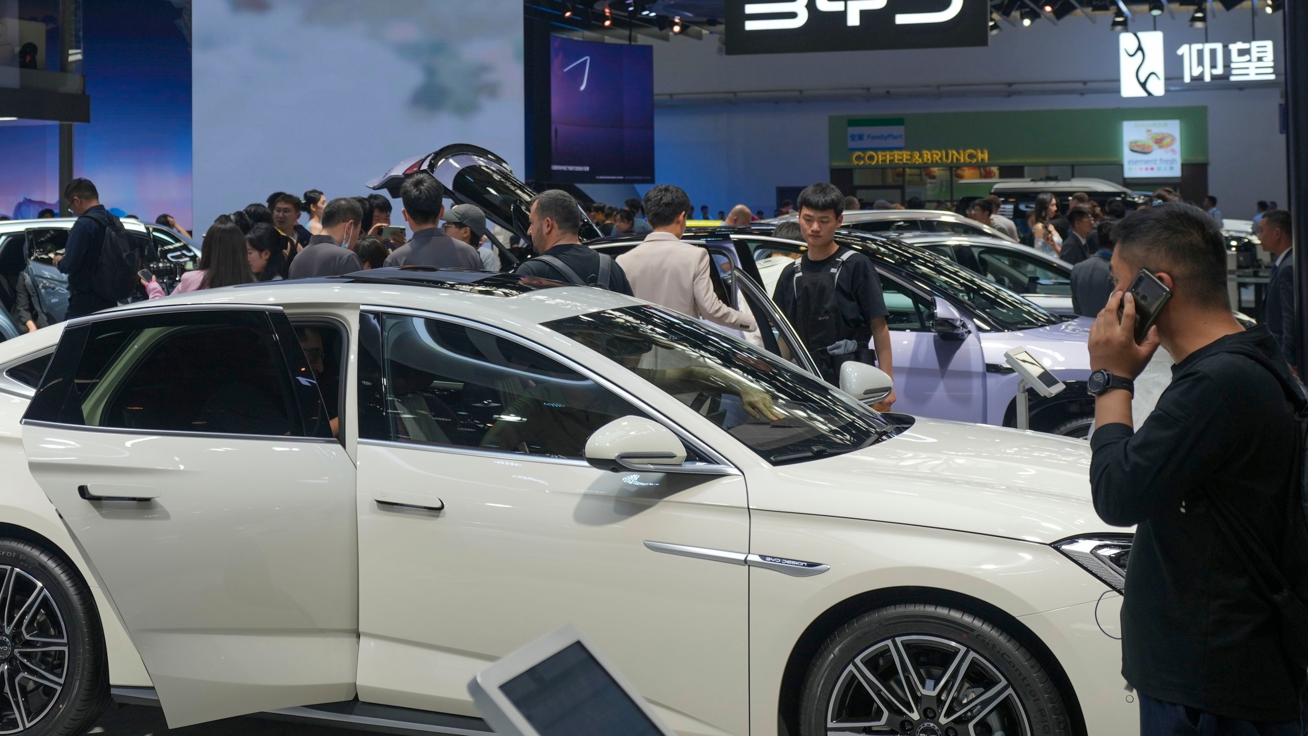 FILE - Visitors look at cars at the BYD booth during the China Auto Show in Beijing, China, April 26, 2024. (AP Photo/Tatan Syuflana, File)