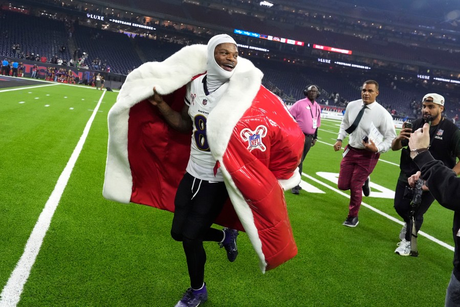 Lamar Jackson, quarterback de los Ravens de Baltimore, abandona el campo con un abrigo de Santa Claus, tras la victoria sobre los Texans de Houston, el miércoles 25 de diciembre de 2024 (AP Foto/David J. Phillip)