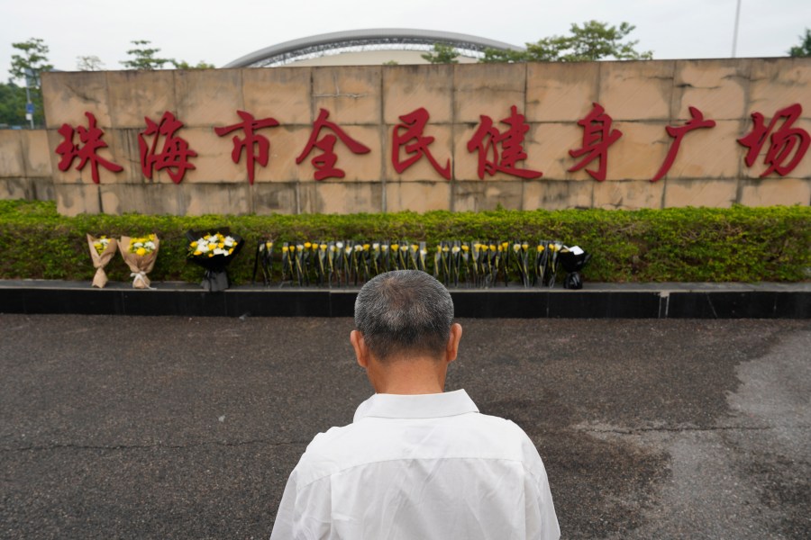 A man stands near flowers laid outside the Zhuhai People's Fitness Plaza, where a man rammed his car into people exercising at the sports center, in Zhuhai in southern China's Guangdong province on Wednesday, Nov. 13, 2024. (AP Photo/Ng Han Guan, File)