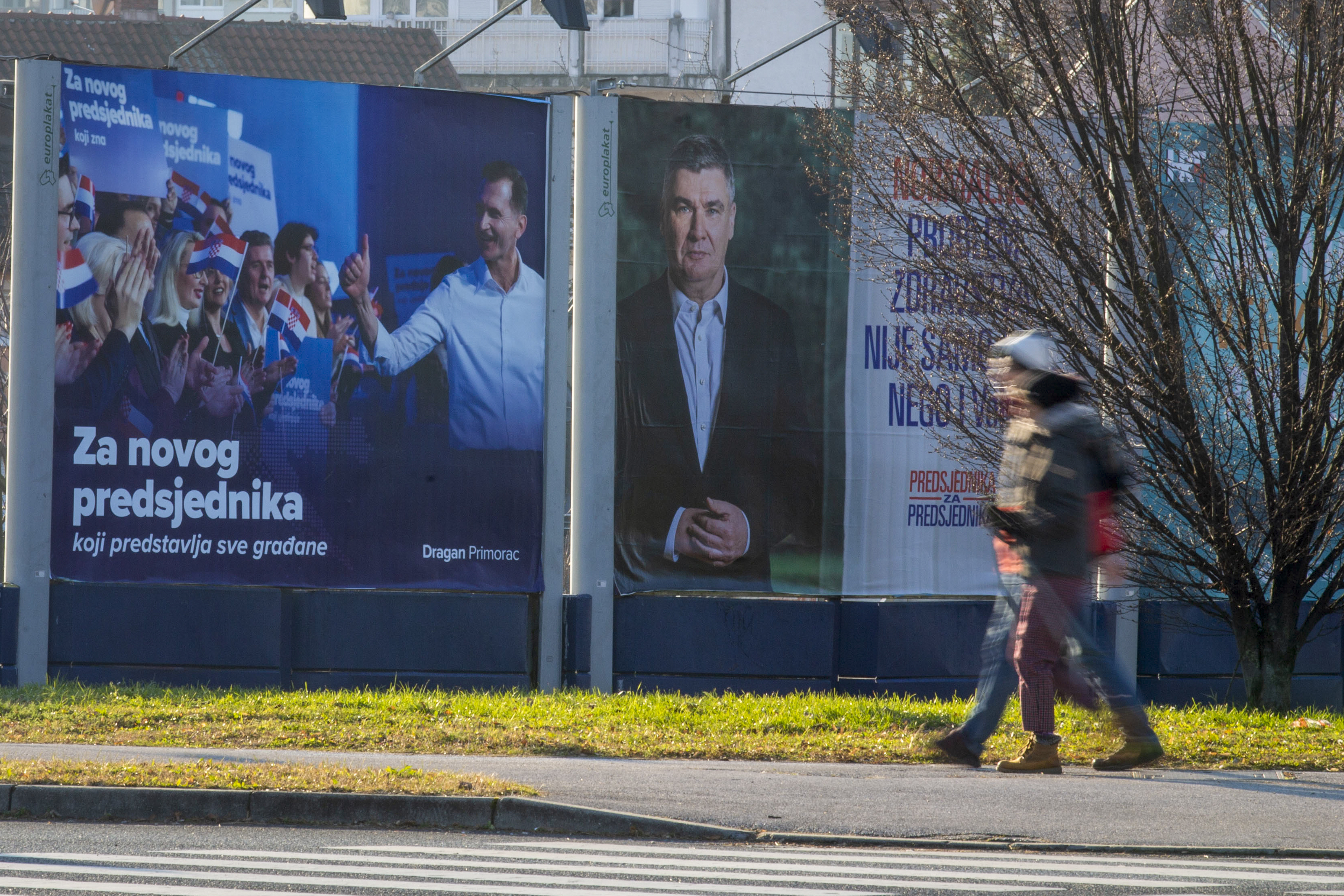 Pedestrians walk past campaign posters of presidential candidates Dragan Primorac and Zoran Milanovic ahead of the presidential election in Zagreb, Croatia, Thursday, Dec. 26, 2024. (AP Photo)