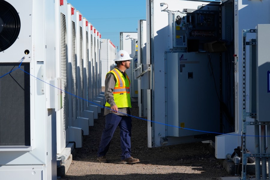 FILE - A worker does checks on battery storage pods at Orsted's Eleven Mile Solar Center lithium-ion battery storage energy facility, Feb. 29, 2024, in Coolidge, Ariz. (AP Photo/Ross D. Franklin, File)