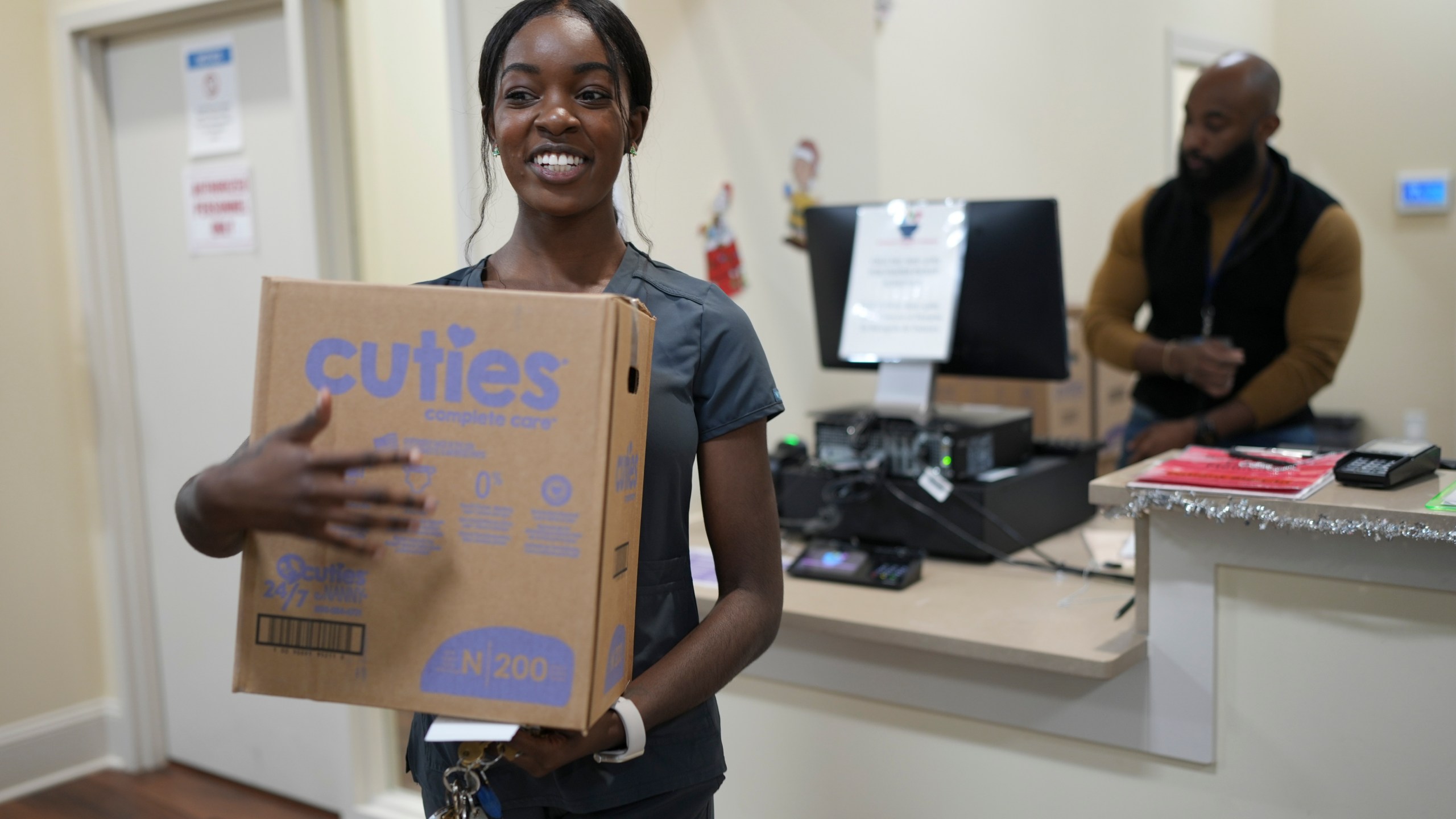 Tatayanna Johnson carries a box of diapers for her child from the Pharmalife Community Pharmacy, Monday, Dec. 9, 2024, in Murfreesboro, Tenn. Johnson participates in the states TennCare Diaper Benefit, which provides free diapers for children under the age of two. (AP Photo/George Walker IV)