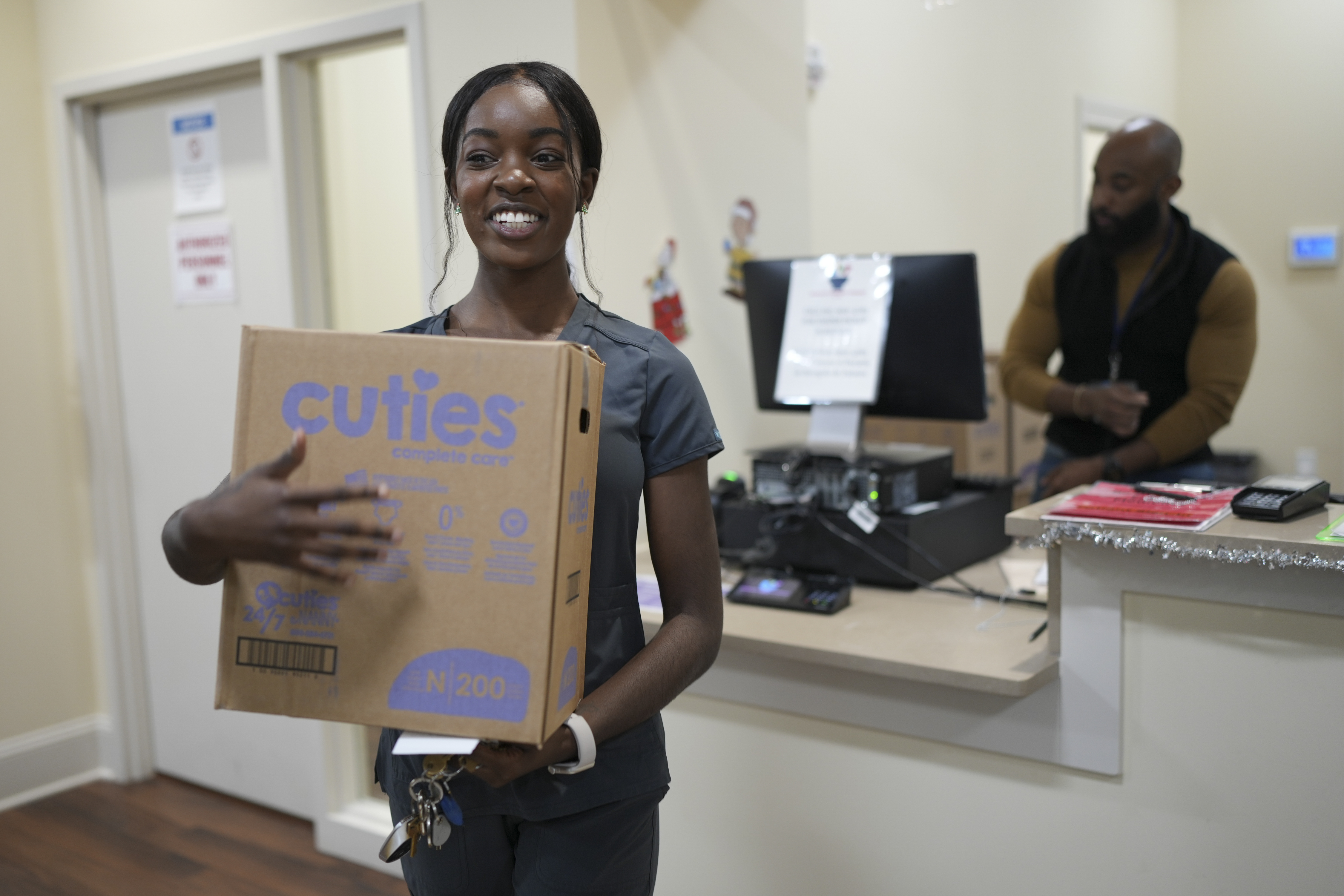 Tatayanna Johnson carries a box of diapers for her child from the Pharmalife Community Pharmacy, Monday, Dec. 9, 2024, in Murfreesboro, Tenn. Johnson participates in the states TennCare Diaper Benefit, which provides free diapers for children under the age of two. (AP Photo/George Walker IV)