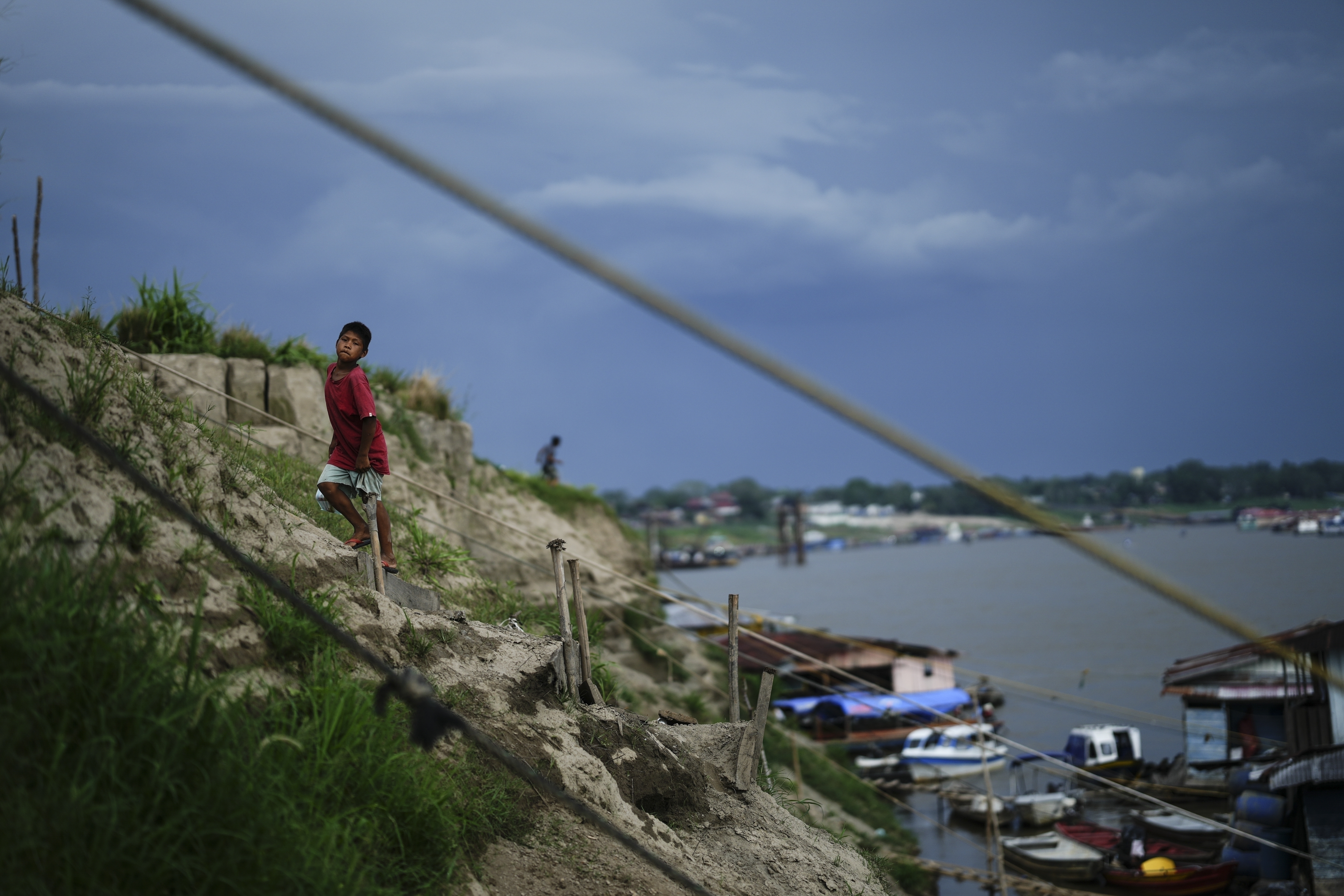 FILE - A boy climbs a hill near a low Amazon River due to the drought, in Leticia, Colombia, Oct. 20, 2024. (AP Photo/Ivan Valencia, File)