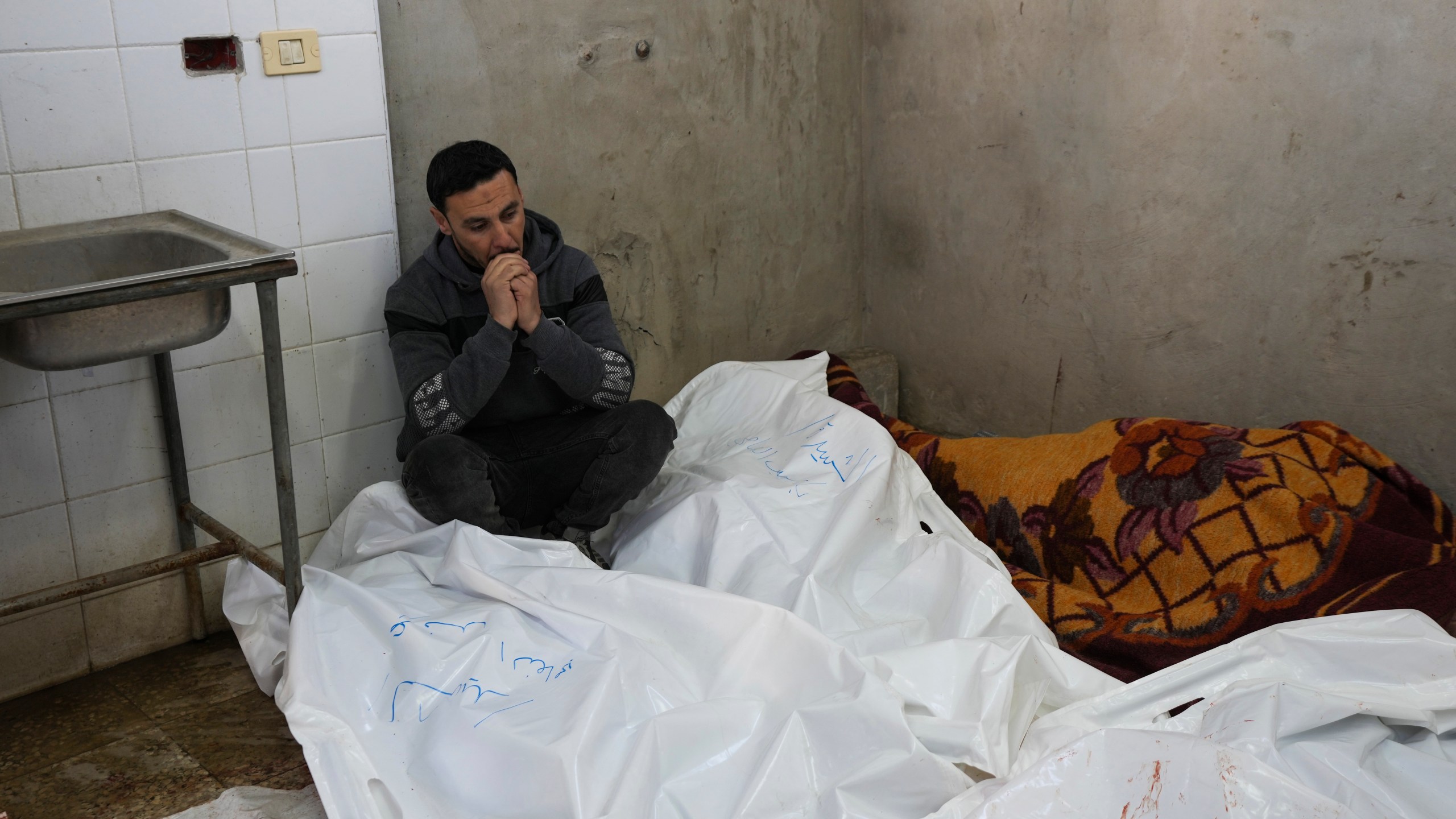 A Palestinian man sits mourning relatives killed in overnight Israeli airstrikes on the Maghazi refugee camp, at Al-Aqsa Hospital, in Deir al-Balah, central Gaza Strip, Saturday, Dec. 28, 2024. (AP Photo/Abdel Kareem Hana)