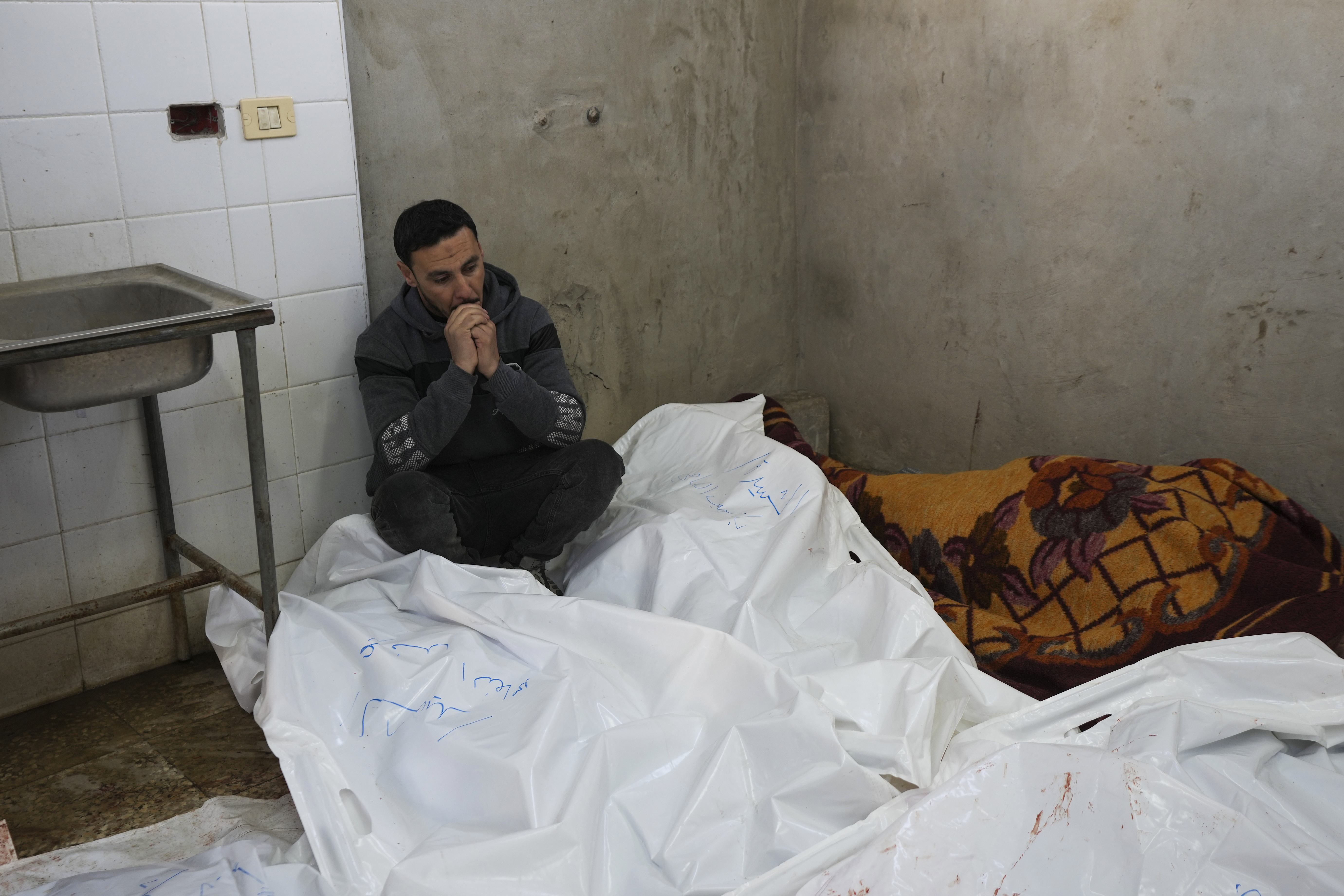 A Palestinian man sits mourning relatives killed in overnight Israeli airstrikes on the Maghazi refugee camp, at Al-Aqsa Hospital, in Deir al-Balah, central Gaza Strip, Saturday, Dec. 28, 2024. (AP Photo/Abdel Kareem Hana)