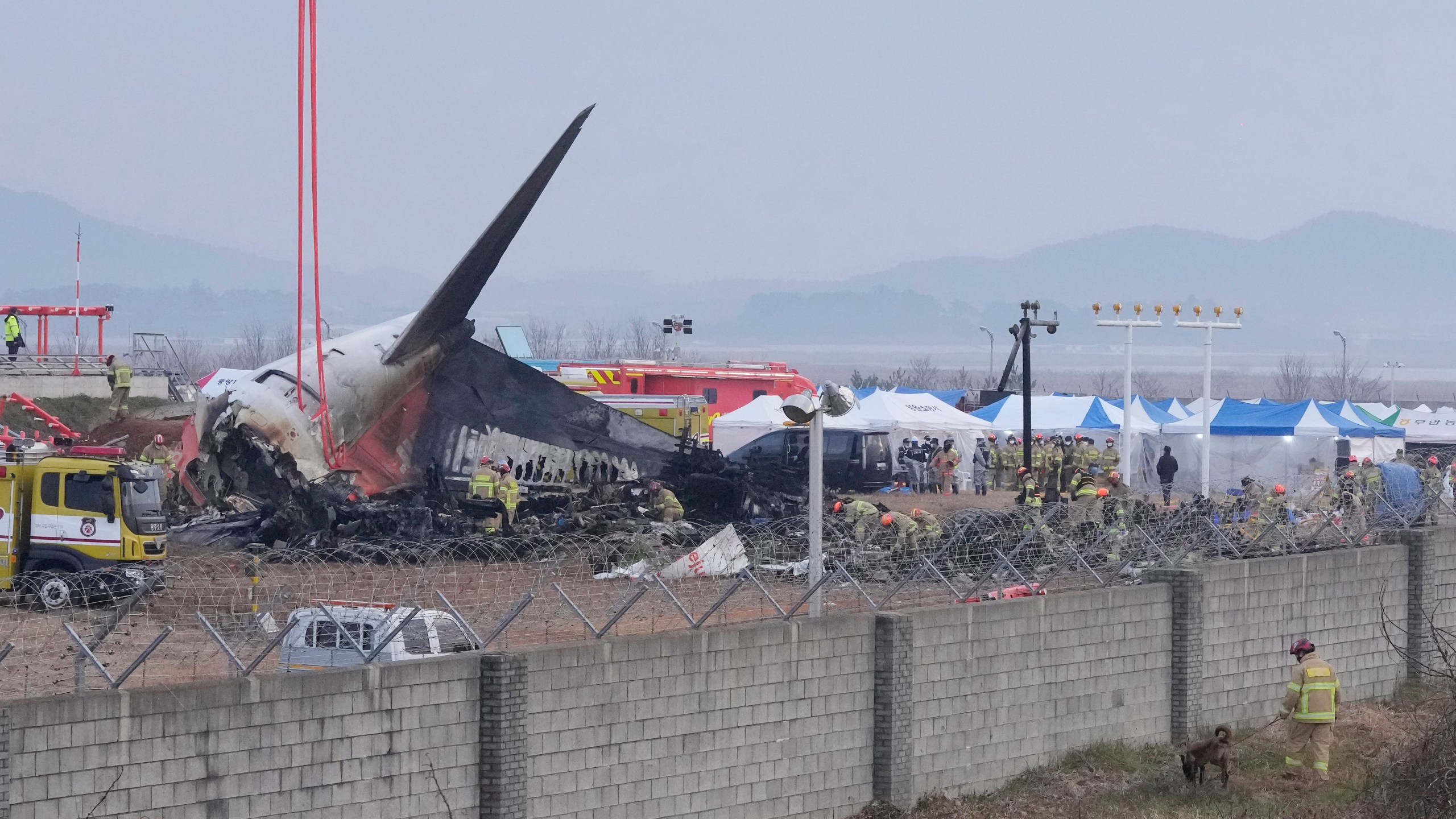 Rescue team members work at the site of a plane fire at Muan International Airport in Muan, South Korea, Monday, Dec. 30, 2024. (AP Photo/Ahn Young-joon)