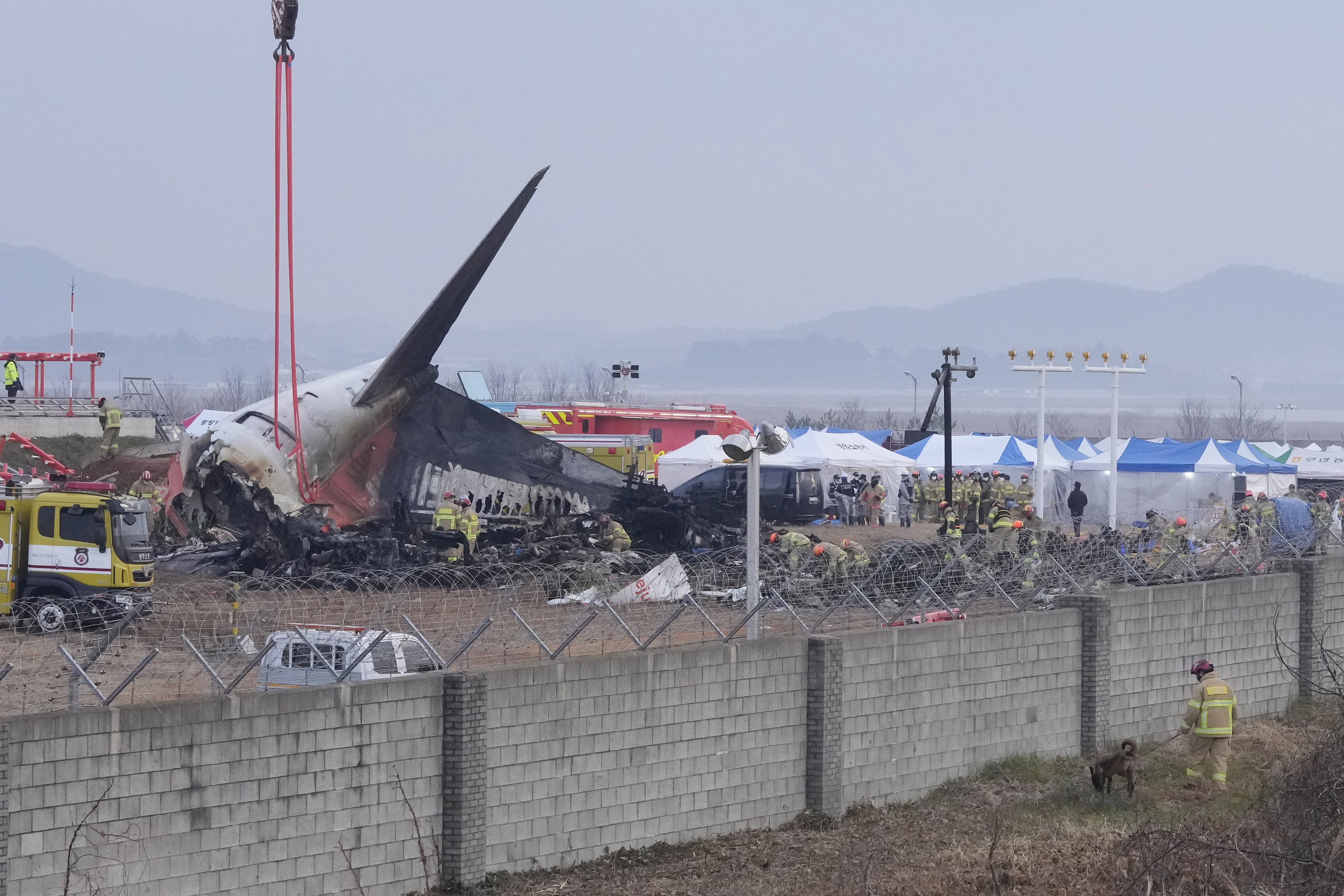 Rescue team members work at the site of a plane fire at Muan International Airport in Muan, South Korea, Monday, Dec. 30, 2024. (AP Photo/Ahn Young-joon)