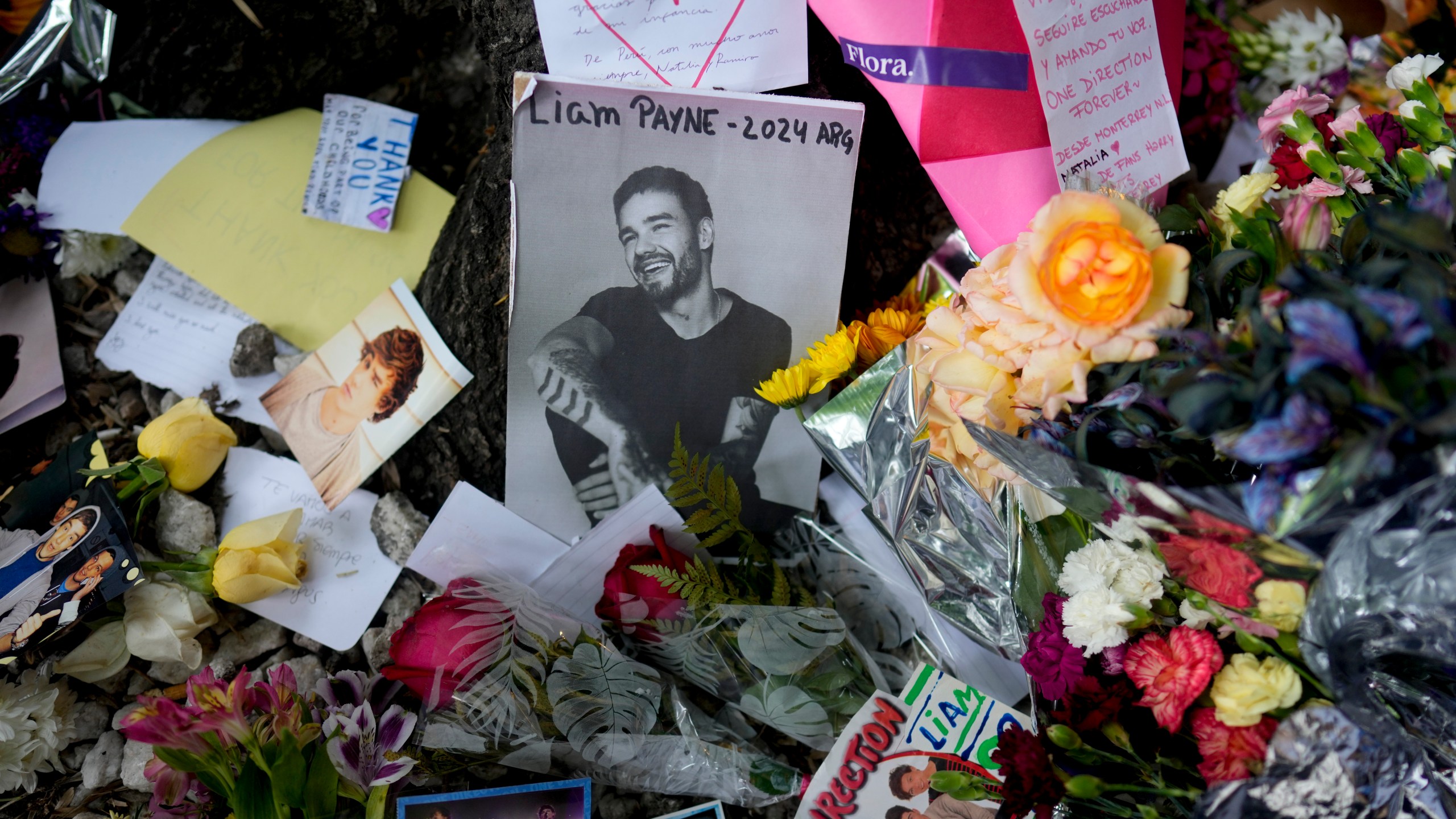 FILE - A picture of former One Direction singer Liam Payne sits surrounded by flowers and candles as fans gather outside the hotel where he was found dead after falling from a balcony in Buenos Aires, Argentina, Oct. 17, 2024. (AP Photo/Natacha Pisarenko, File)