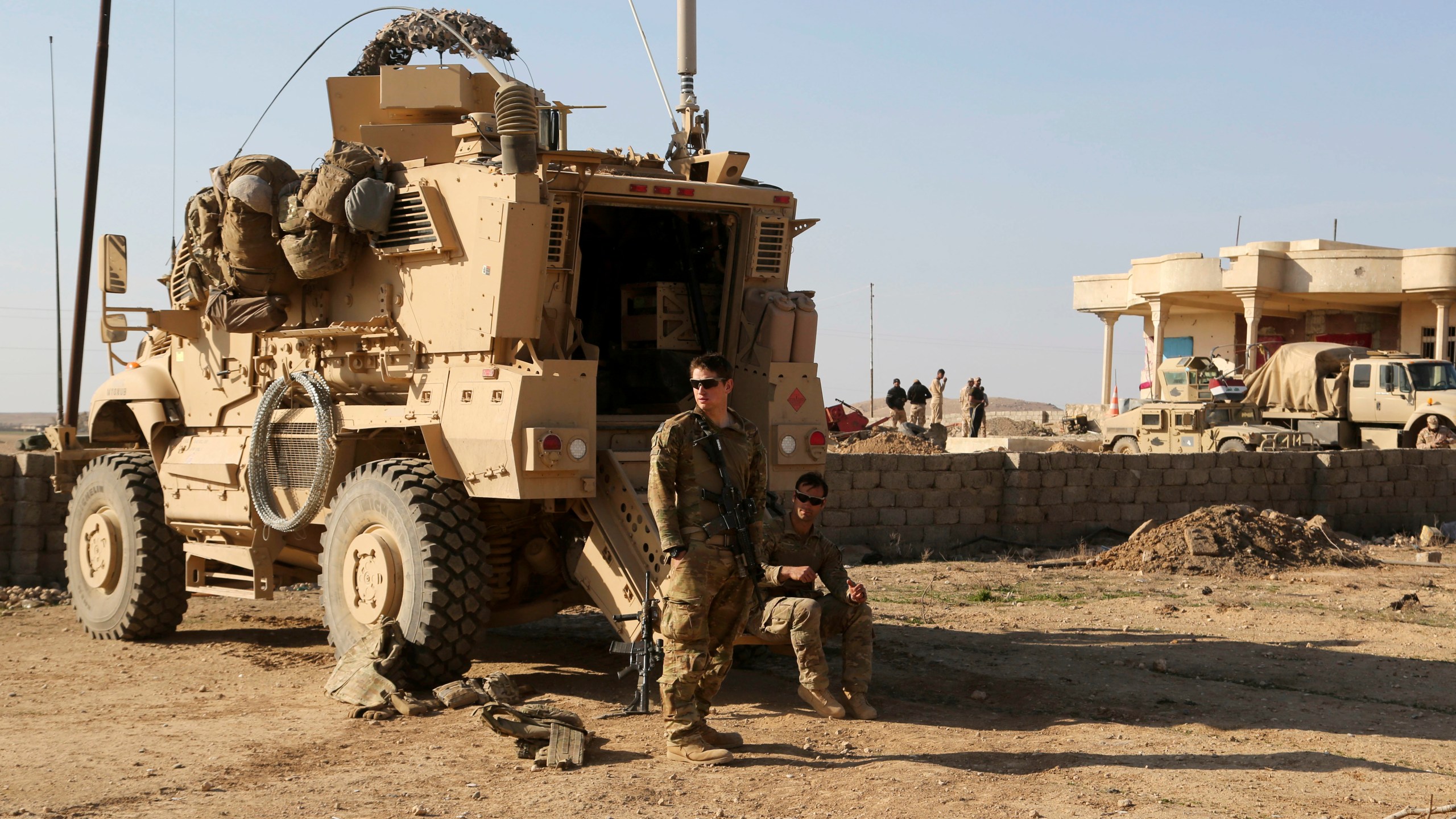 FILE - U.S. Army soldiers stand outside their armored vehicle on a joint base with the Iraqi army, south of Mosul, Iraq, Feb. 23, 2017. (AP Photo/ Khalid Mohammed, File)