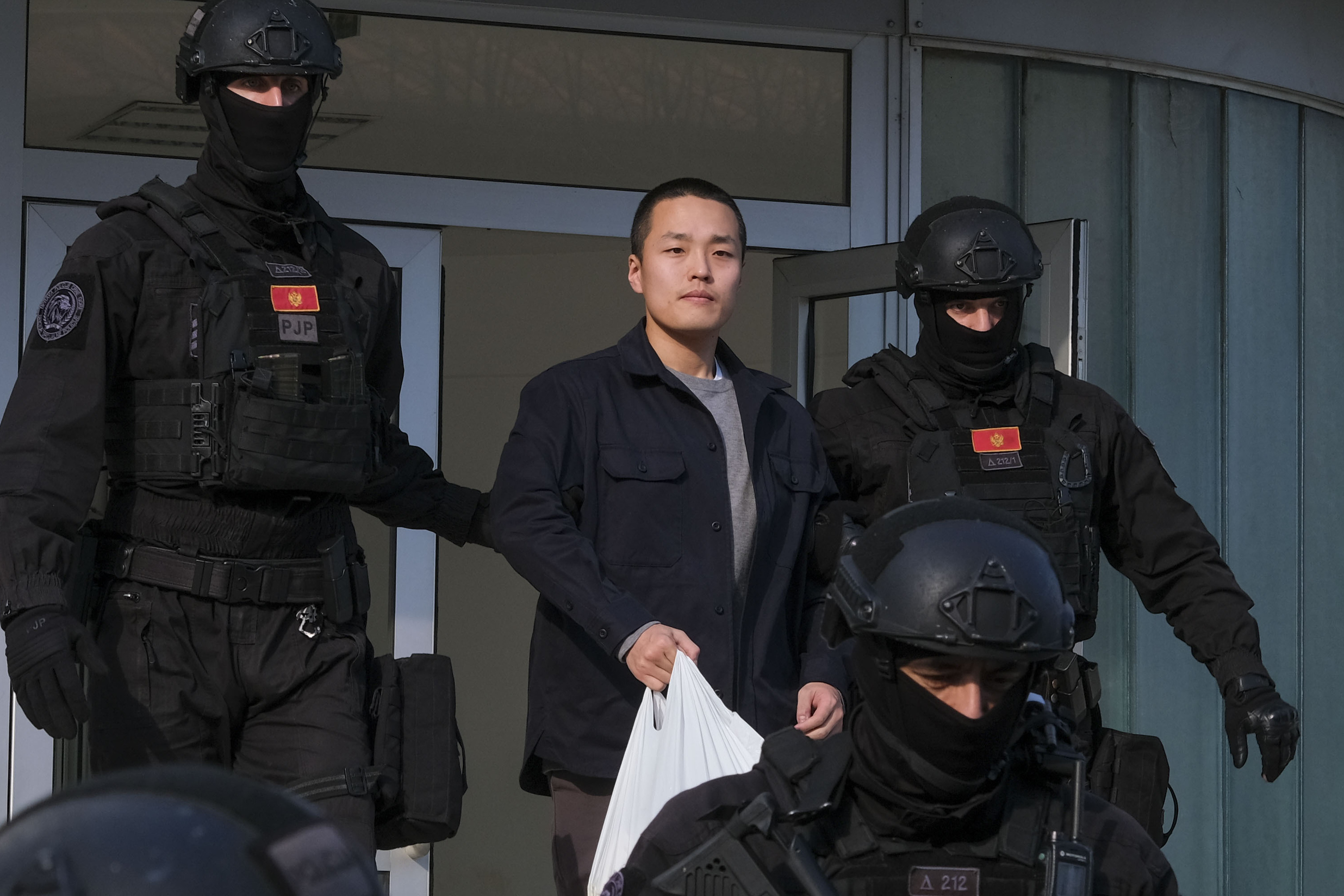 FILE - Montenegrin police officers escort South Korean citizen, Terraform Labs founder Do Kwon in Montenegro's capital Podgorica, Saturday, March 23, 2024. (AP Photo/Risto Bozovic, File)