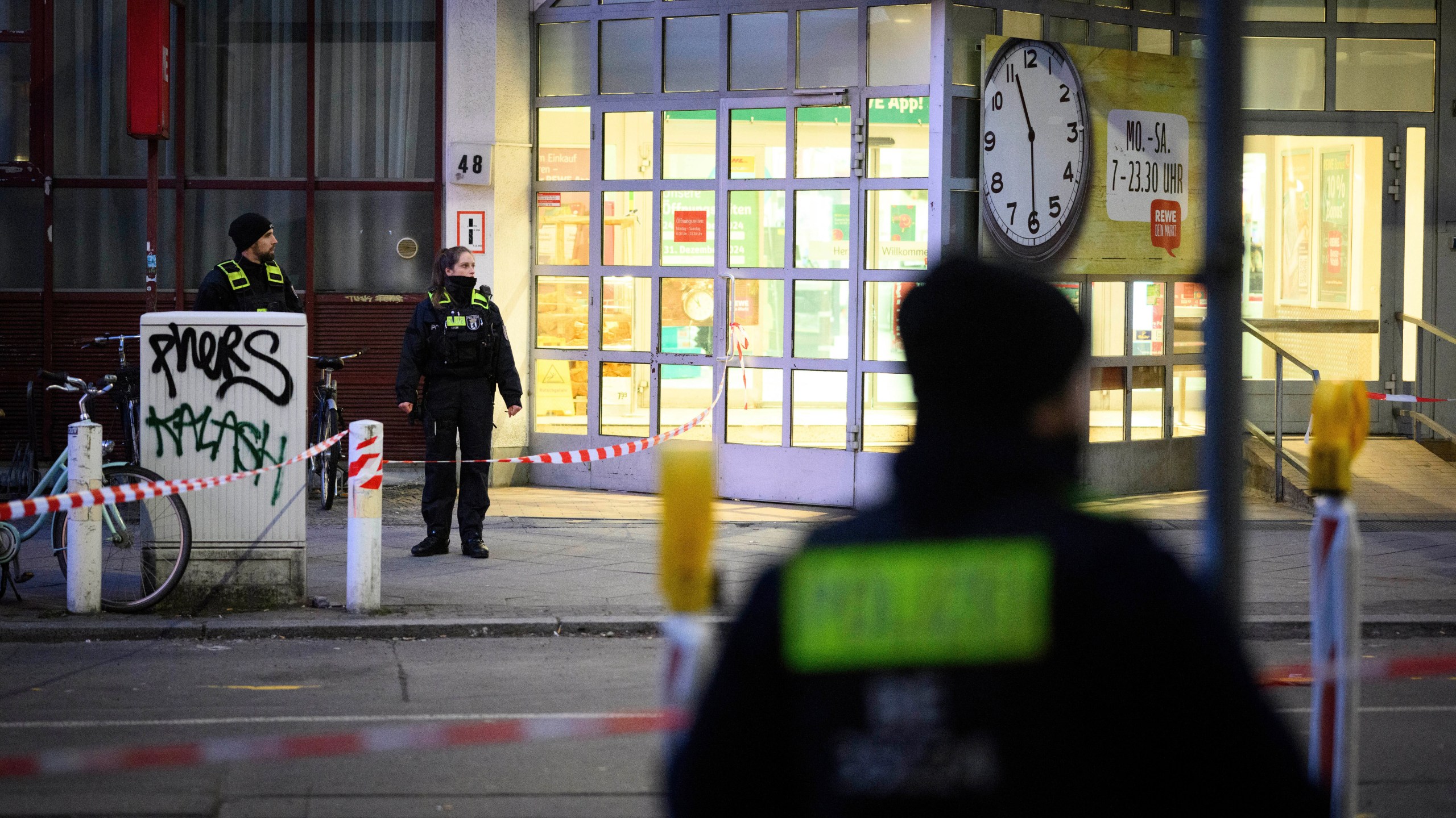 Police officers stand at a cordoned-off area in front of a supermarket in Berlin-Charlottenburg after an incident, in Berlin, Tuesday, Dec. 31, 2024. (Bernd von Jutrczenka/dpa via AP)