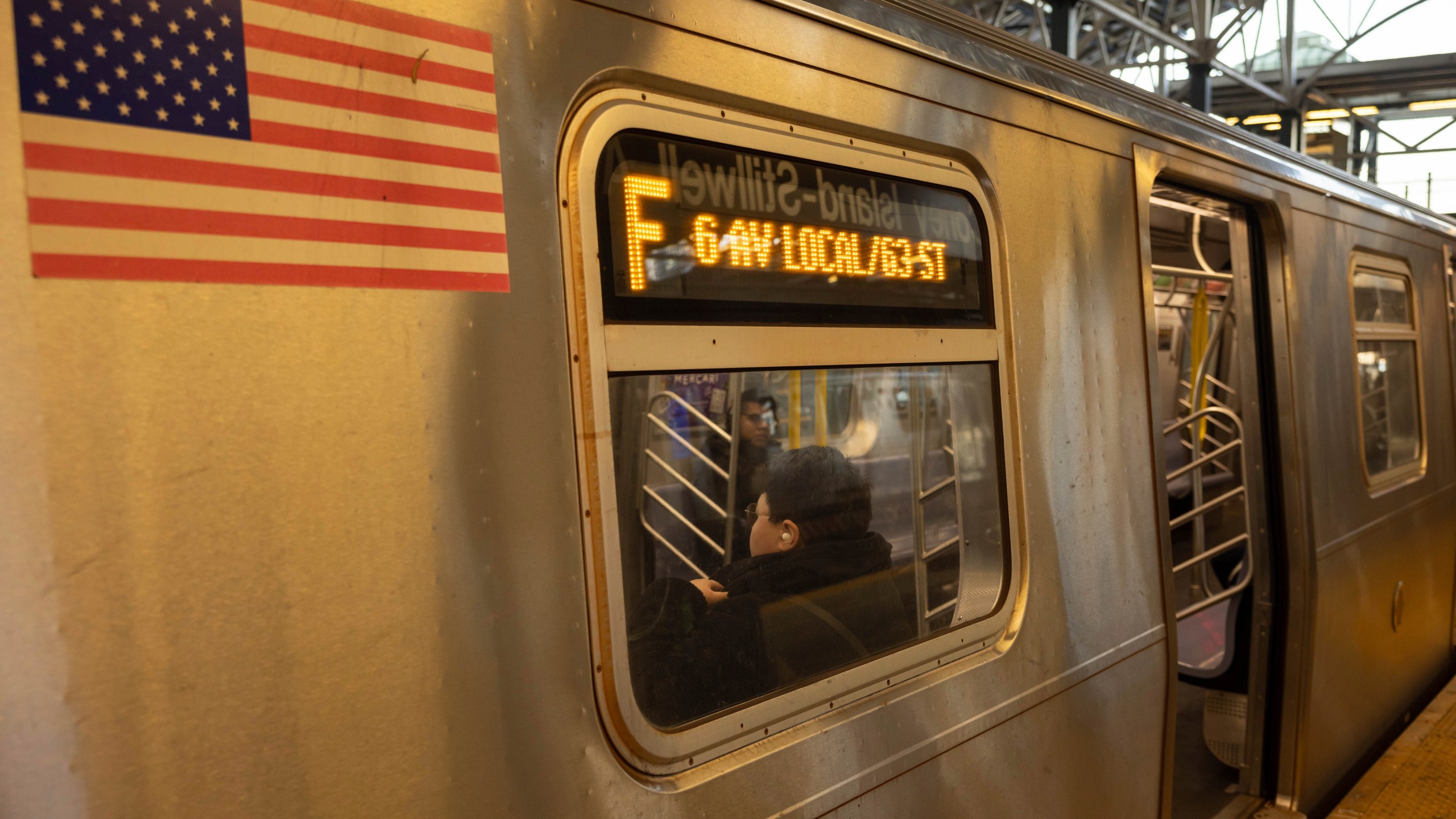 FILE - Commuters sit on the F train at the Coney Island-Stillwell Avenue Station, Thursday, Dec. 26, 2024, in New York. (AP Photo/Yuki Iwamura, File)