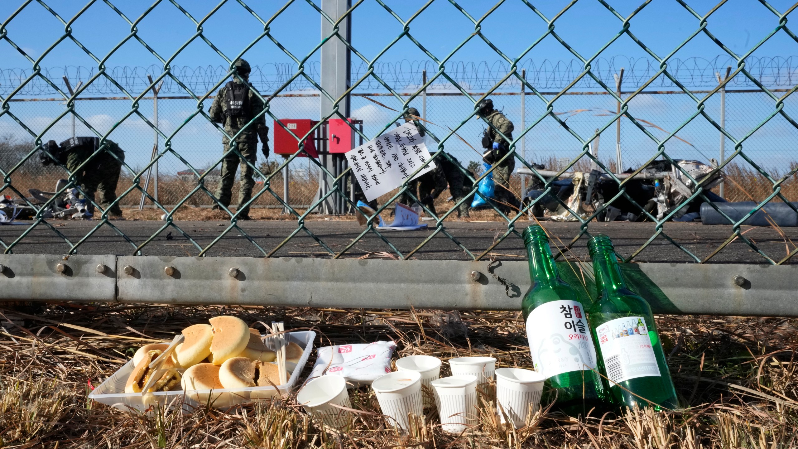 A message of condolences and foods are seen outside of Muan International Airport in Muan, South Korea, Tuesday, Dec. 31, 2024, following Sunday's plane crash. (AP Photo/Ahn Young-joon)