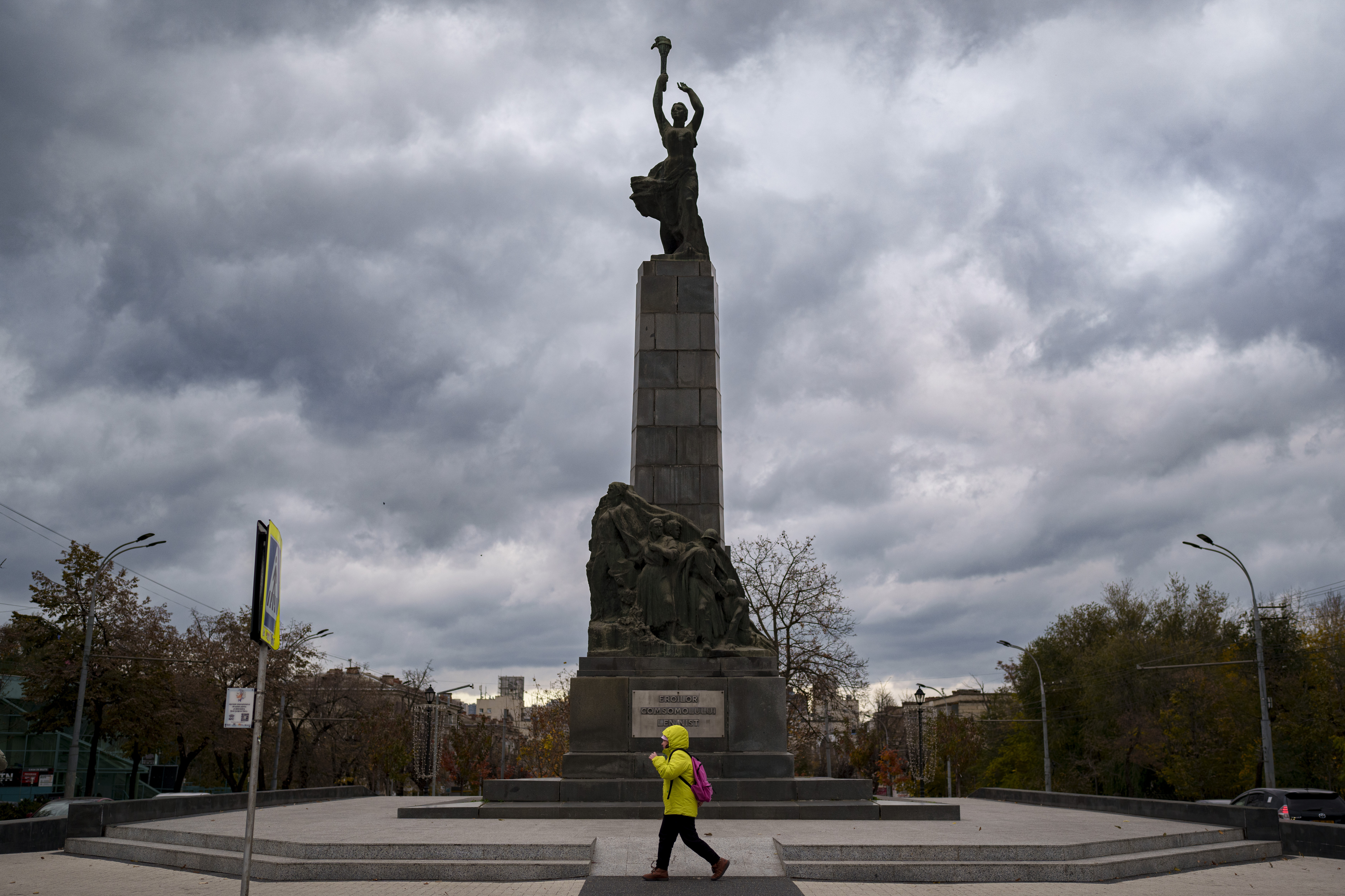 FILE - A person walks by the monument of the Leninist Komsomol Heroes, a political youth organization in the Soviet Union, in Chisinau, Moldova, Monday, Nov. 4, 2024. (AP Photo/Vadim Ghirda, File)