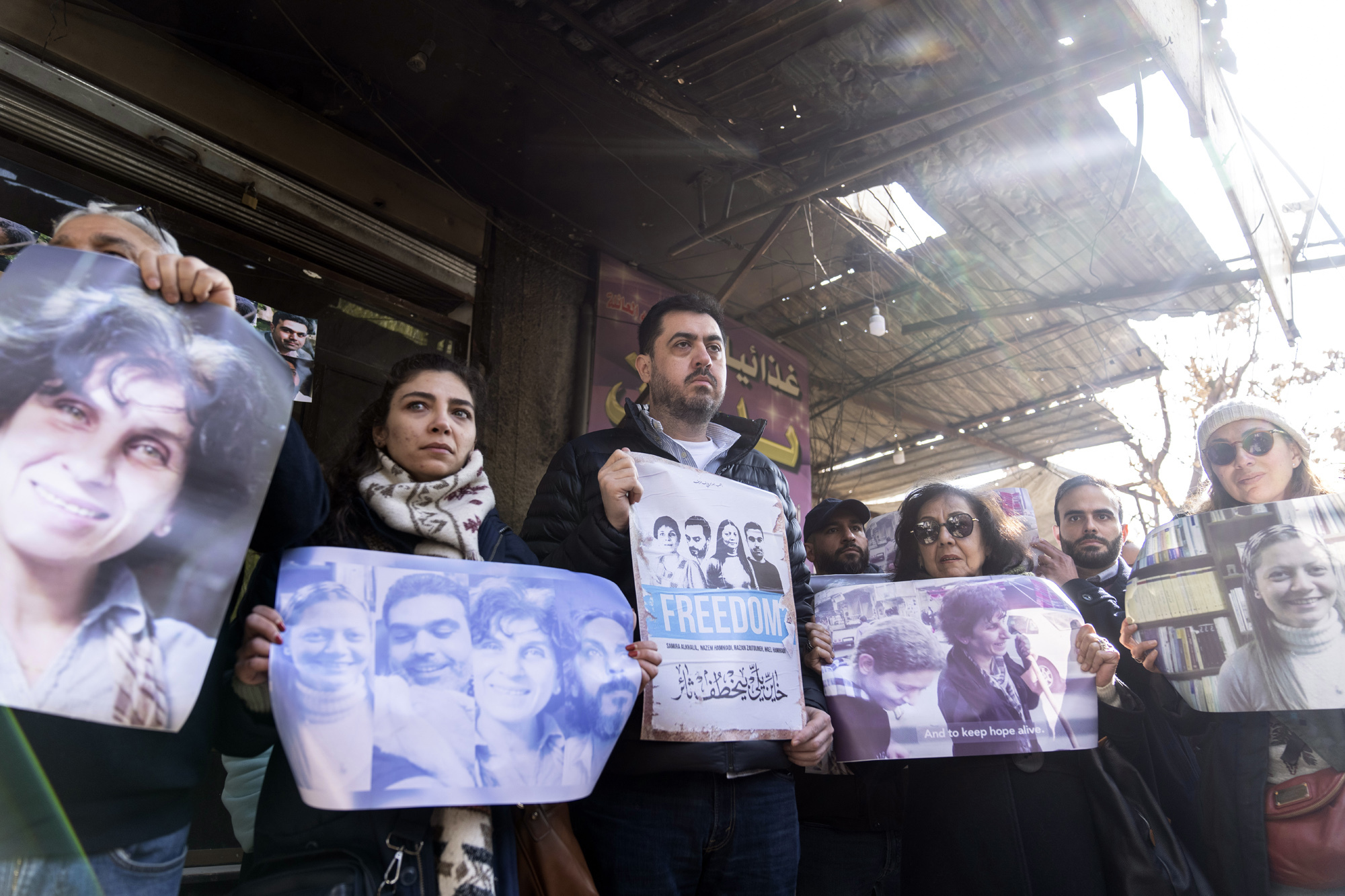 Activists and relatives take part in a protest demanding the whereabouts of four activists who disappeared during the war between opposition groups and former President Bashar Assad's forces, in Douma, Syria, Wednesday, Jan. 1, 2025. (AP Photo/Mosa'ab Elshamy)