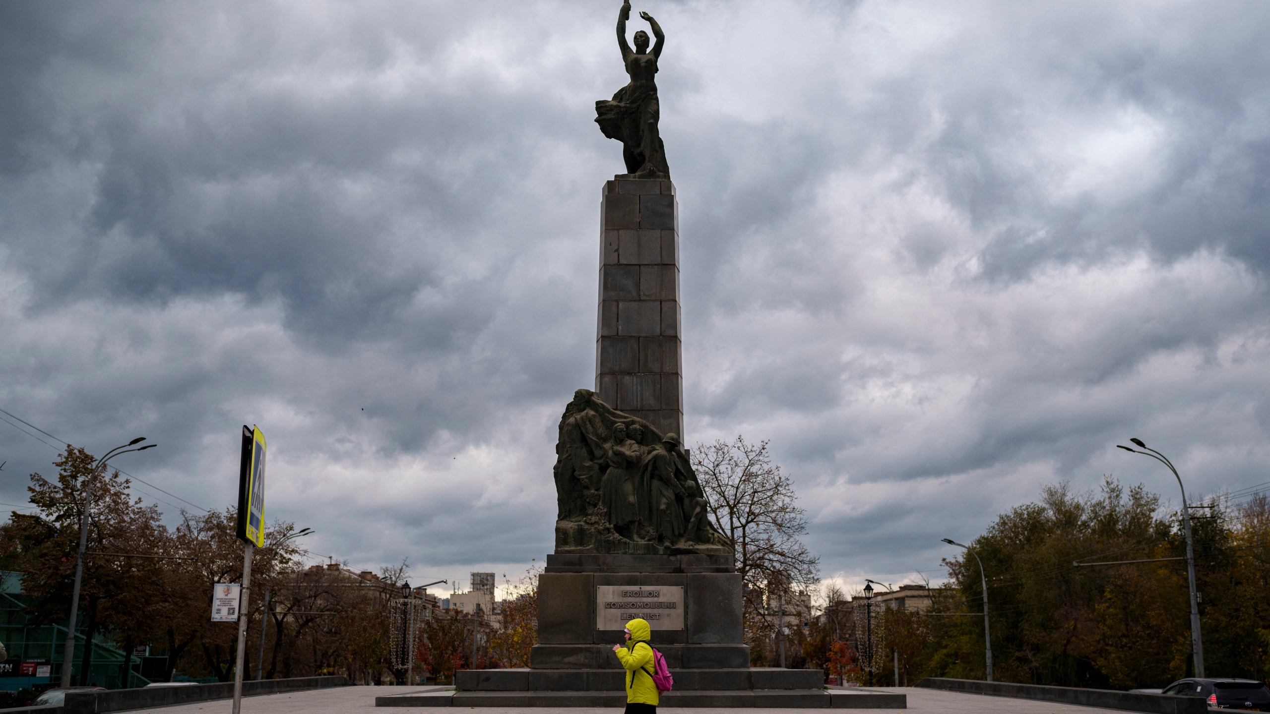 FILE - A person walks by the monument of the Leninist Komsomol Heroes, a political youth organization in the Soviet Union, in Chisinau, Moldova, Monday, Nov. 4, 2024. (AP Photo/Vadim Ghirda, File)