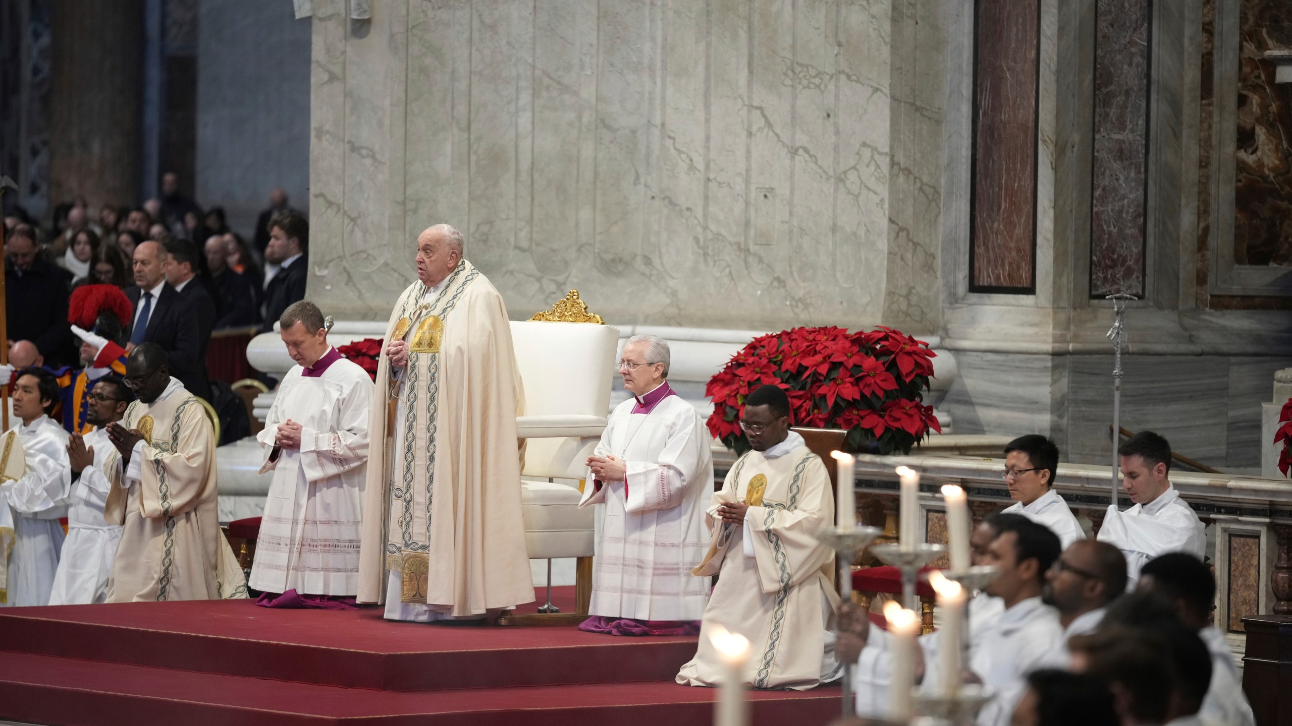 Pope Francis is flanked by Vatican Head Master of Ceremonies, Bishop Diego Giovanni Ravelli, right, and Master of Ceremonies, Bishop Krysztof Marcjanowicz as he presides over a mass in St. Peter's Basilica at The Vatican on New Year's Day, Wednesday, Jan. 1, 2025. (AP Photo/Andrew Medichini)