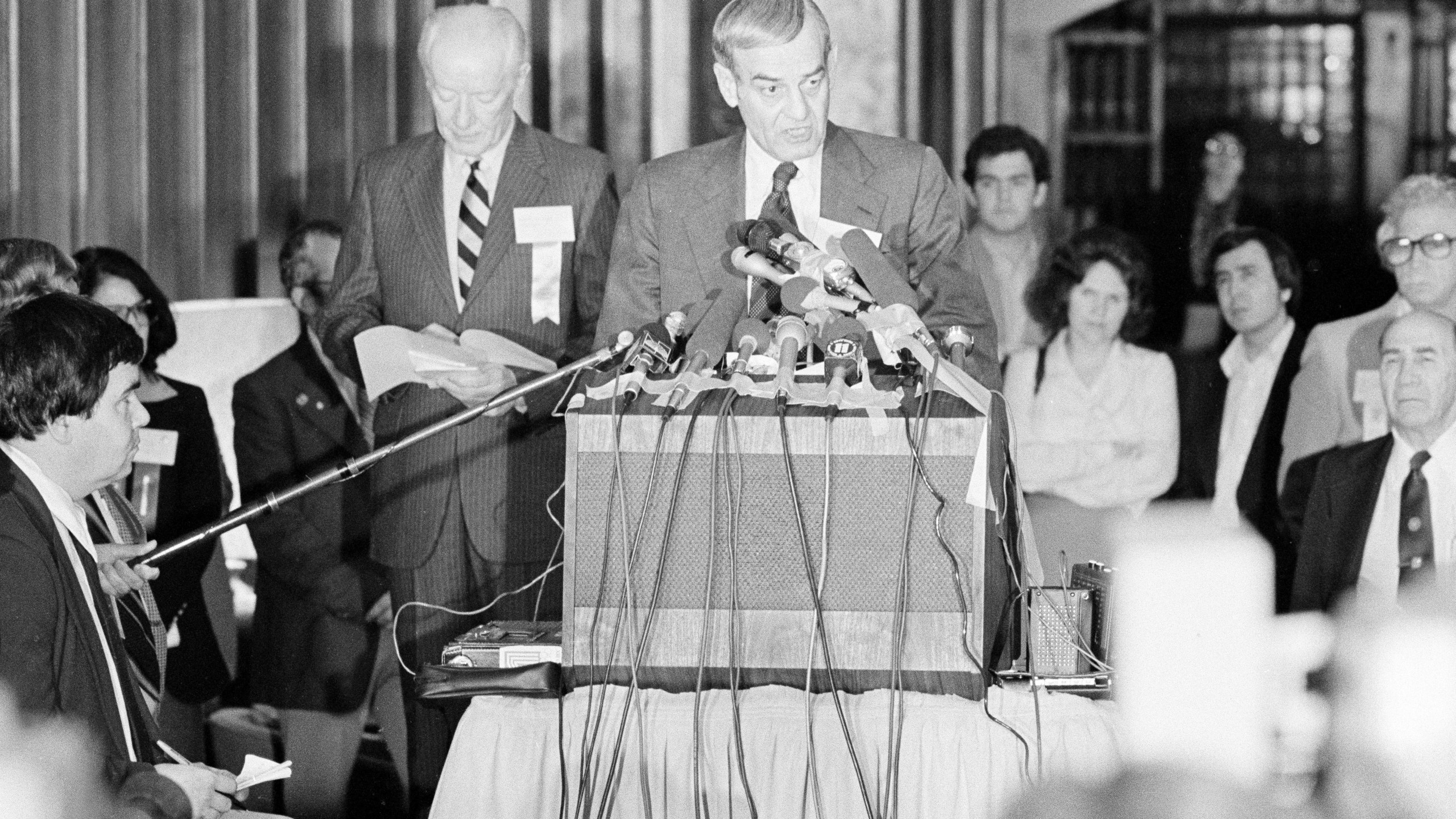 FILE - F. Don Miller, executive director of the U.S. Olympic Committee, reads a resolution adopted by the U.S. Olympic Committee's House of Delegates to boycott the 1980 Summer Games in Moscow, in Colorado Springs, Colo., April 12, 1980. At left is Robert Kane, president of the U.S. Olympic Committee. (AP Photo/Ed Andrieski, File)