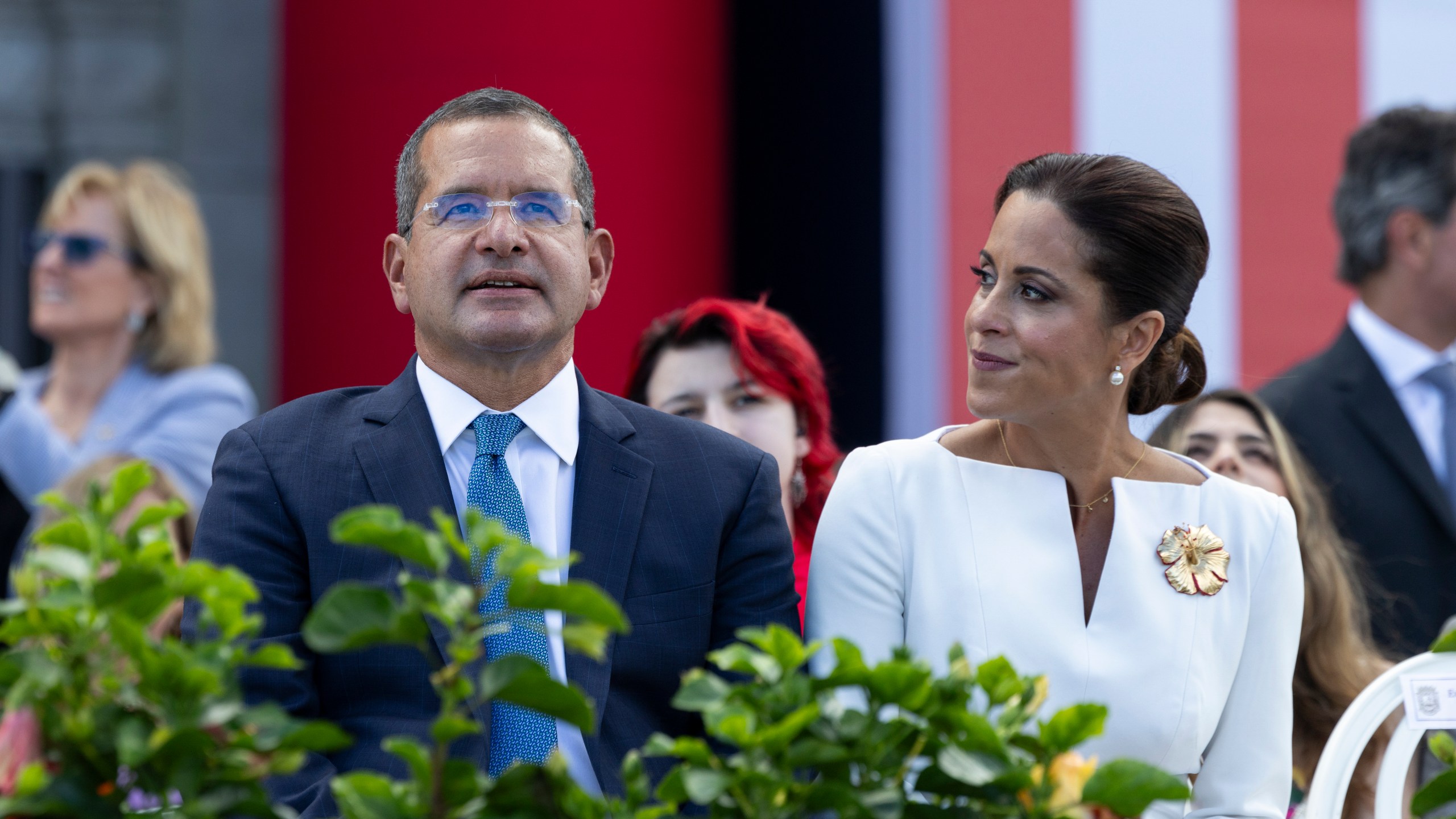 Outgoing Governor Pedro Pierluisi sits with his wife Fabiola Ansotegui during the inauguration ceremony of the new Governor Jenniffer Gonzalez Colon outside the Capitol in San Juan, Puerto Rico. Thursday, Jan. 2, 2025. (AP Photo/Alejandro Granadillo)