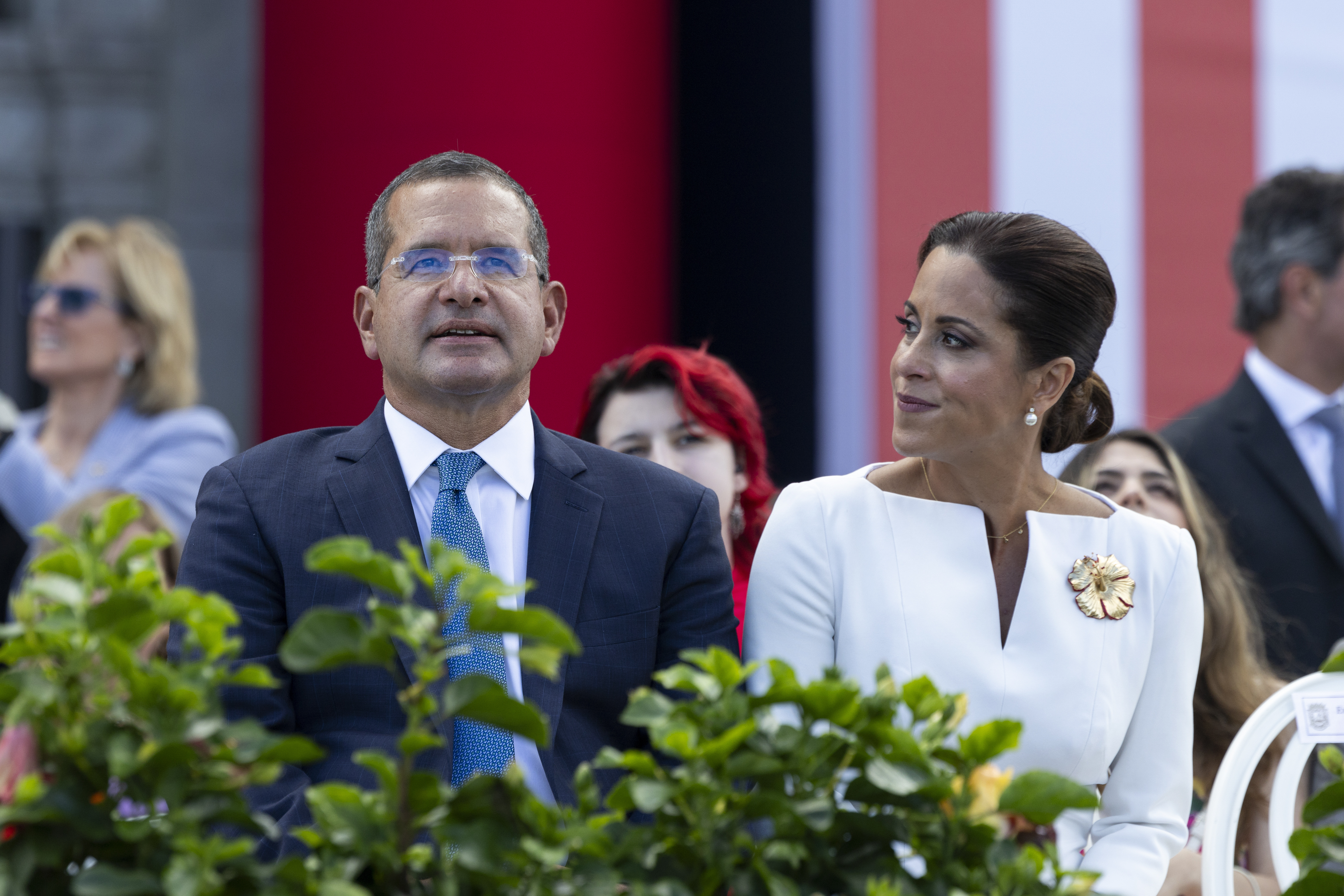 Outgoing Governor Pedro Pierluisi sits with his wife Fabiola Ansotegui during the inauguration ceremony of the new Governor Jenniffer Gonzalez Colon outside the Capitol in San Juan, Puerto Rico. Thursday, Jan. 2, 2025. (AP Photo/Alejandro Granadillo)