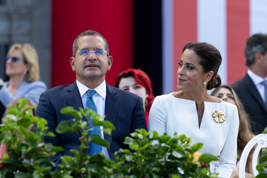 Outgoing Governor Pedro Pierluisi sits with his wife Fabiola Ansotegui during the inauguration ceremony of the new Governor Jenniffer Gonzalez Colon outside the Capitol in San Juan, Puerto Rico. Thursday, Jan. 2, 2025. (AP Photo/Alejandro Granadillo)