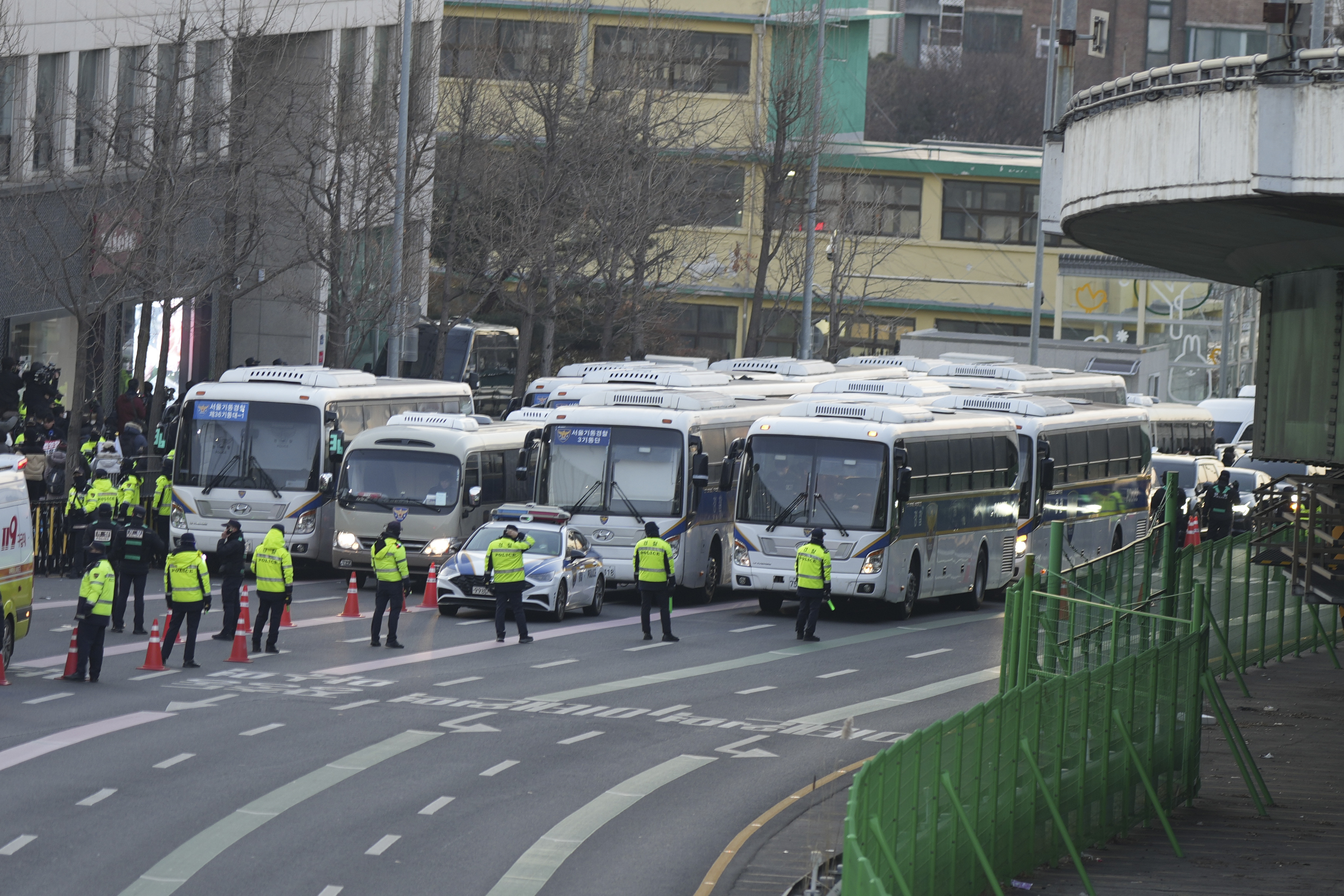 Police vehicles are seen near the gate of the presidential residence as supporters of impeached South Korean President Yoon Suk Yeol stage a rally to oppose a court having issued a warrant to detain Yoon, in Seoul, South Korea, Friday, Jan. 3, 2025. (AP Photo/Lee Jin-man)