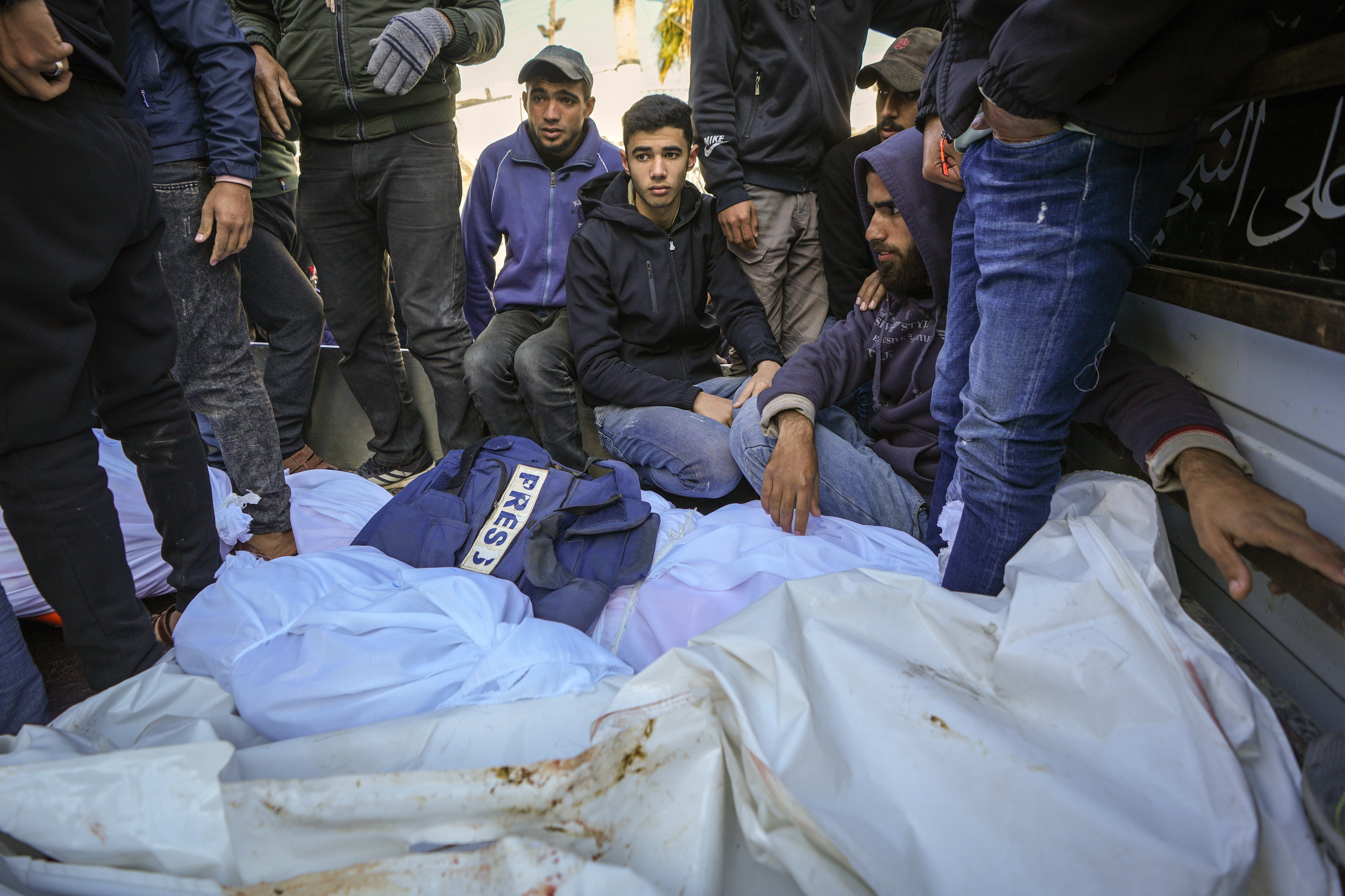 Colleagues and friends mourn over the body of freelance journalist Omar al-Derawi and other victims of overnight Israeli army strikes at multiple locations in central Gaza Strip, at Al-Aqsa Martyrs Hospital in Deir al-Balah, Friday, Jan. 3, 2025. According to Al-Aqsa Martyrs Hospital, 30 people, including 10 women and 7 children, were killed in several attacks overnight in central Gaza. (AP Photo/Abdel Kareem Hana)