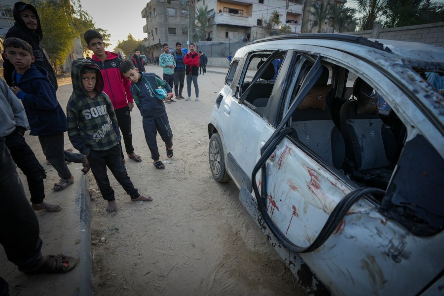 REMOVES NUMBER OF KILLED - Palestinian boys examine a car targeted in an Israeli army strike that killed several of its occupants in Deir al-Balah, central Gaza Strip, Friday, Jan. 3, 2025. (AP Photo/Abdel Kareem Hana)