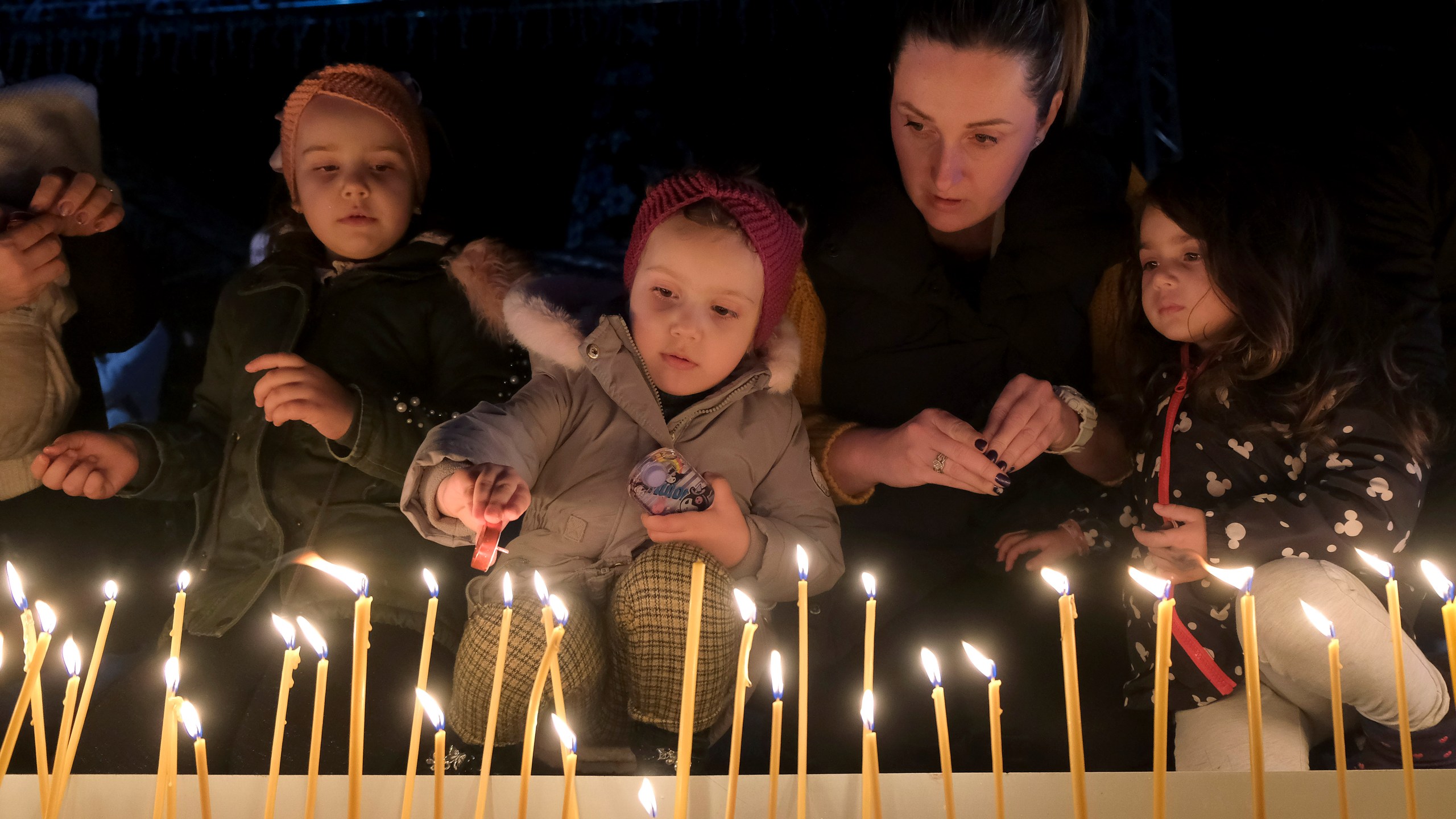 People light candles for the victims of the Wednesday's shooting rampage in Cetinje, in Podogrica, Montenegro, Thursday, Jan. 2, 2025. (AP Photo/Risto Bozovic)