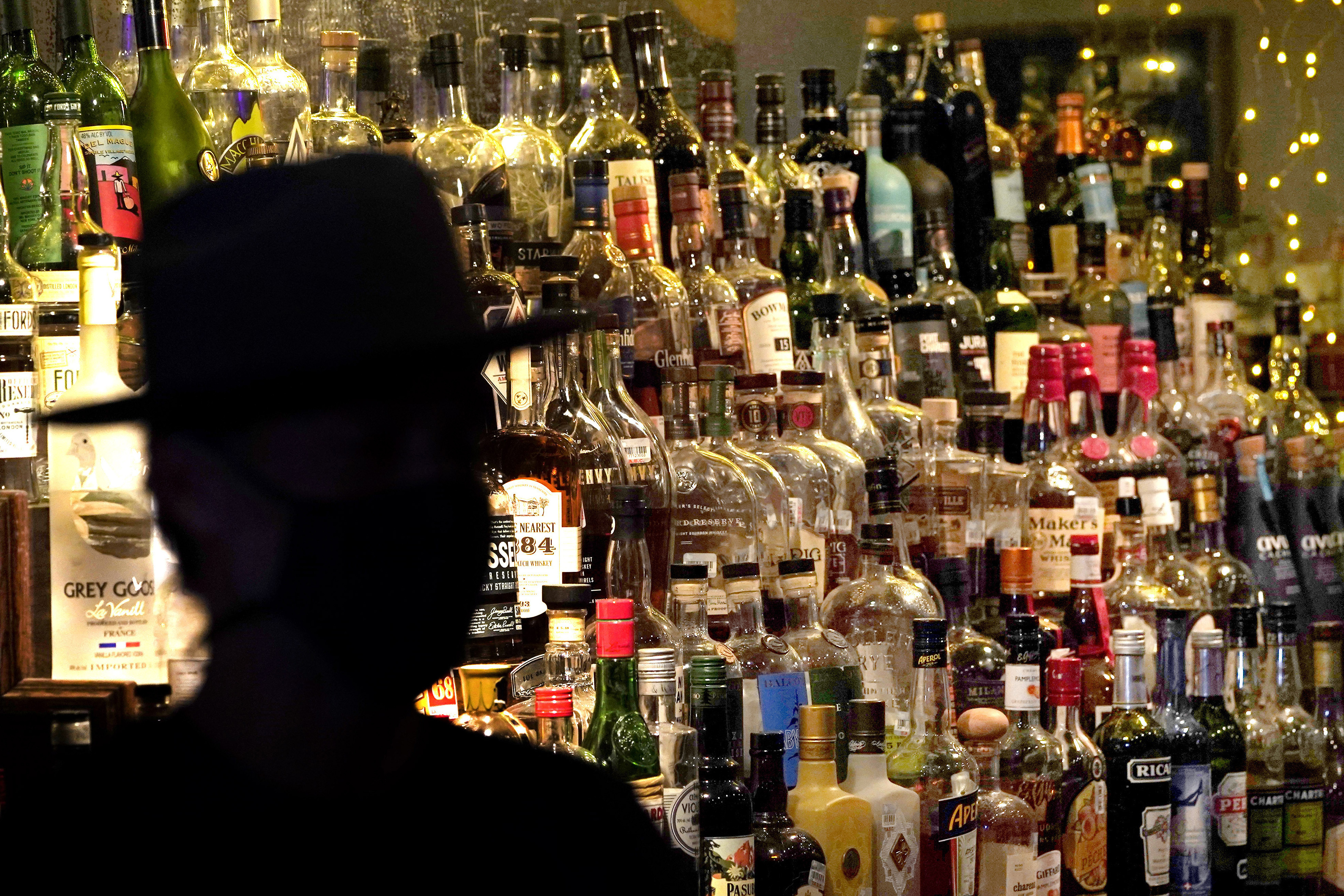 FILE - Bottles of alcohol sit on shelves at a bar in Houston, June 23, 2020. (AP Photo/David J. Phillip, File)