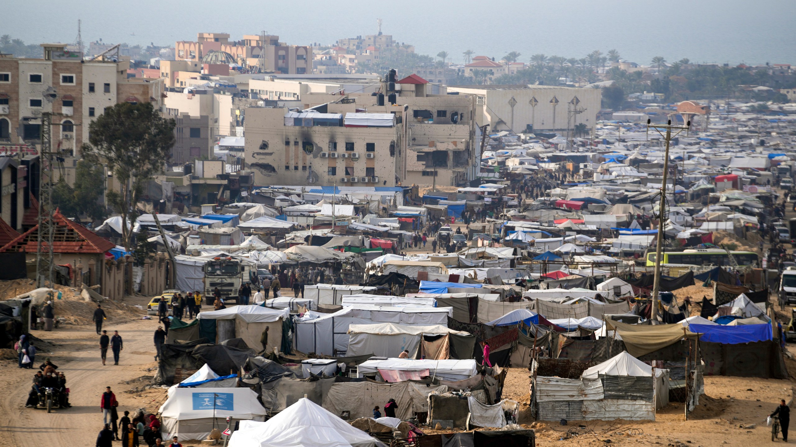 A tent camp for displaced Palestinians is set up amid destroyed buildings in the Khan Younis refugee camp, southern Gaza Strip, Saturday, Jan. 4, 2025. (AP Photo/Abdel Kareem Hana)