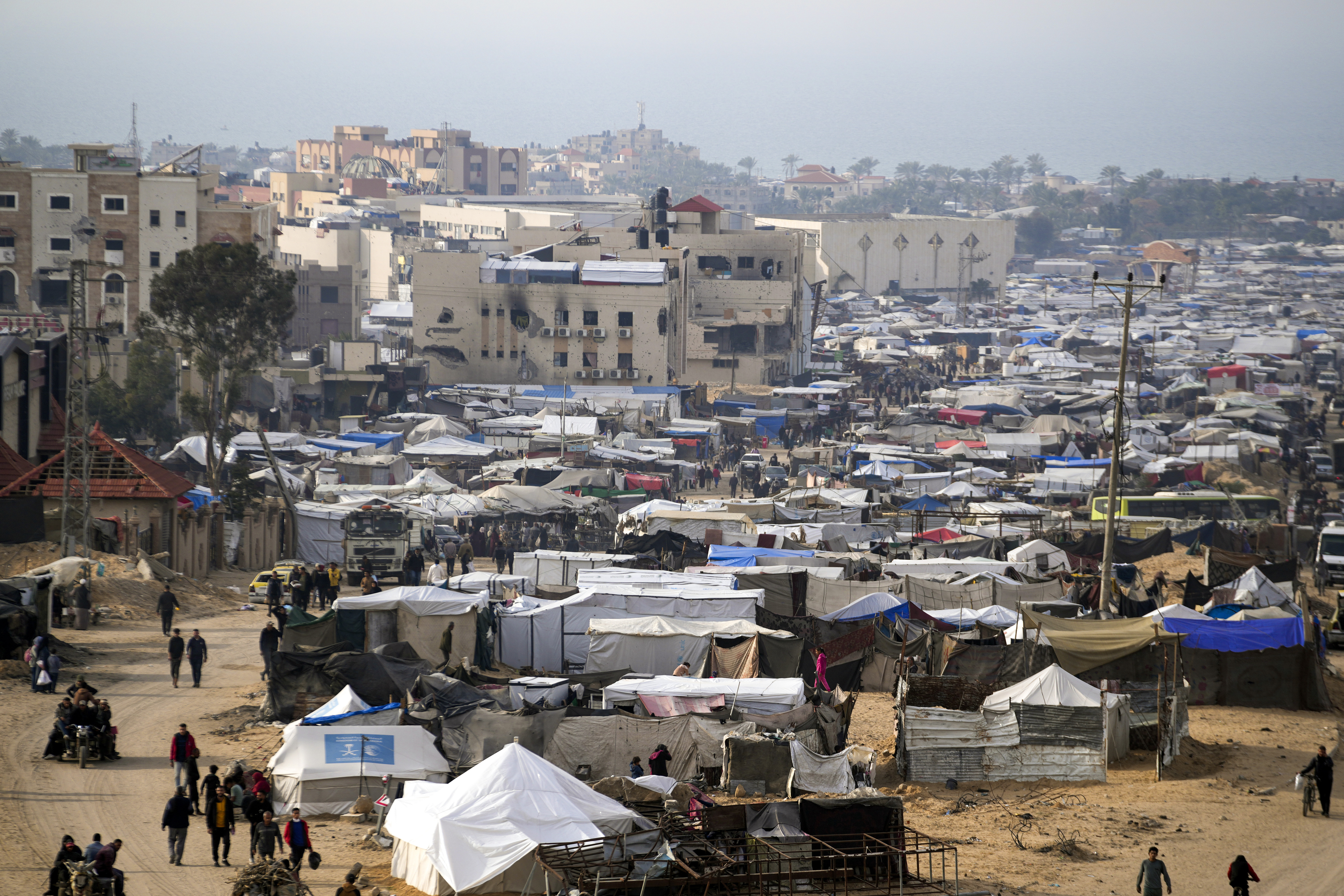 A tent camp for displaced Palestinians is set up amid destroyed buildings in the Khan Younis refugee camp, southern Gaza Strip, Saturday, Jan. 4, 2025. (AP Photo/Abdel Kareem Hana)